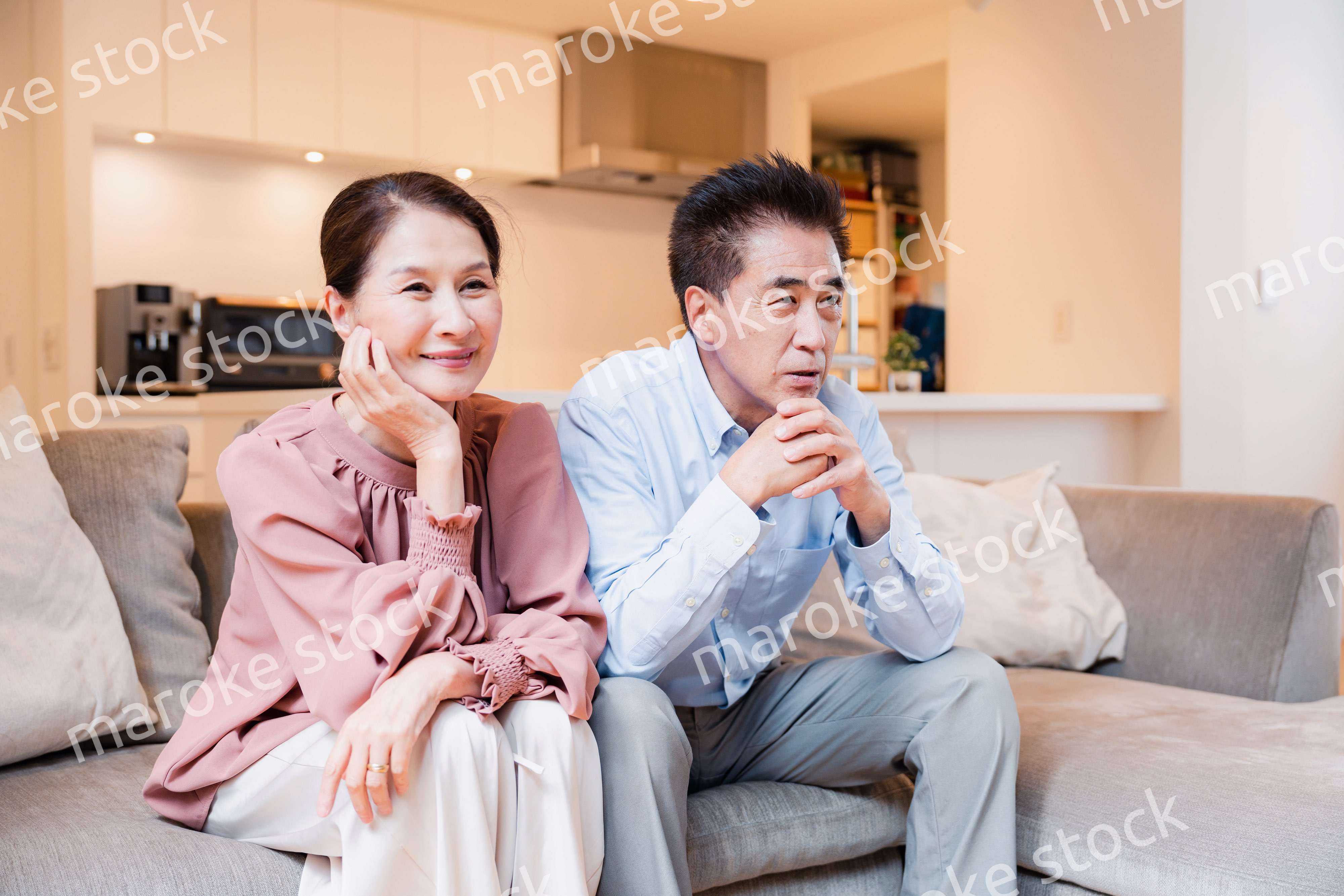 家でテレビを見るシニアの夫婦