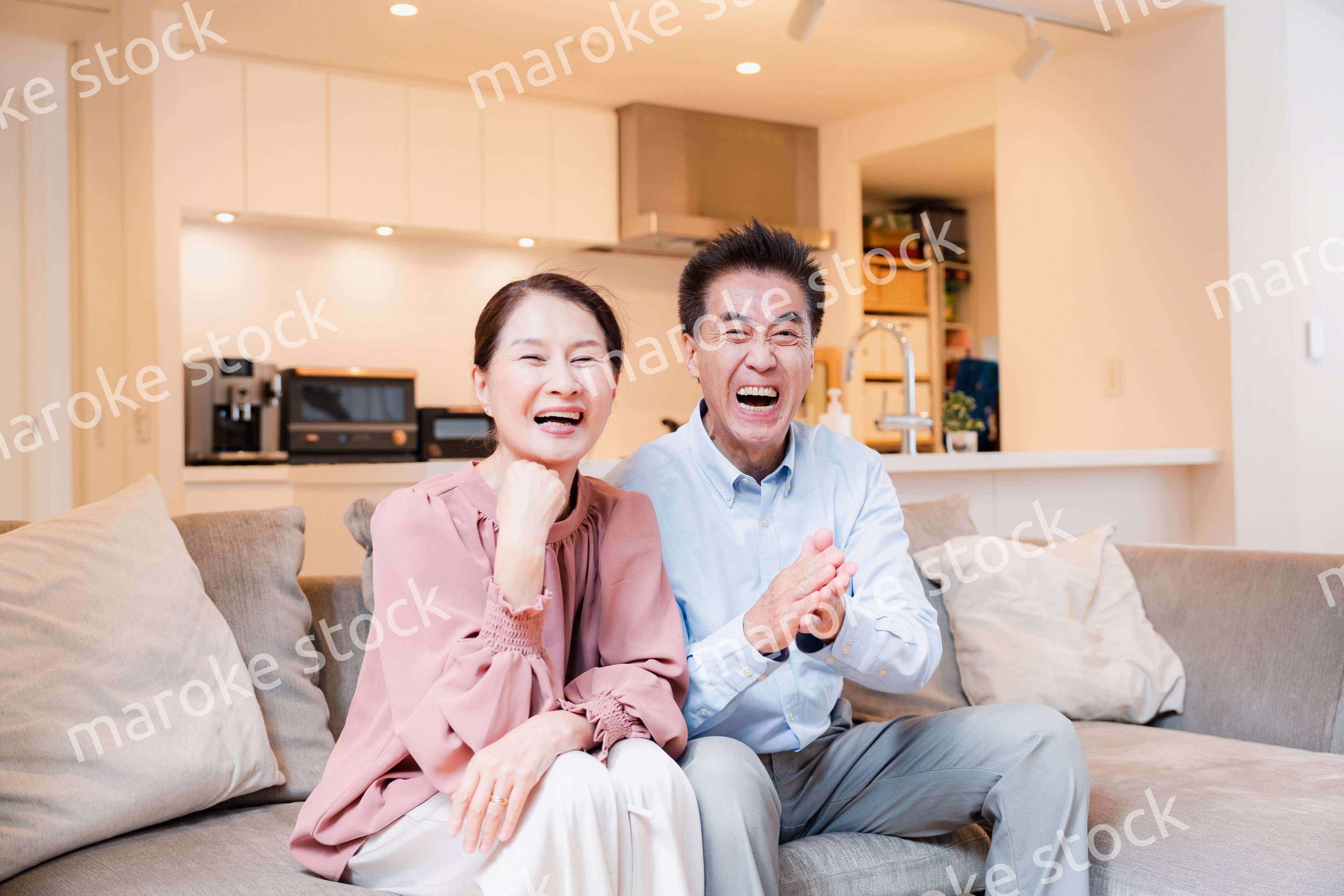 家でテレビを見るシニアの夫婦