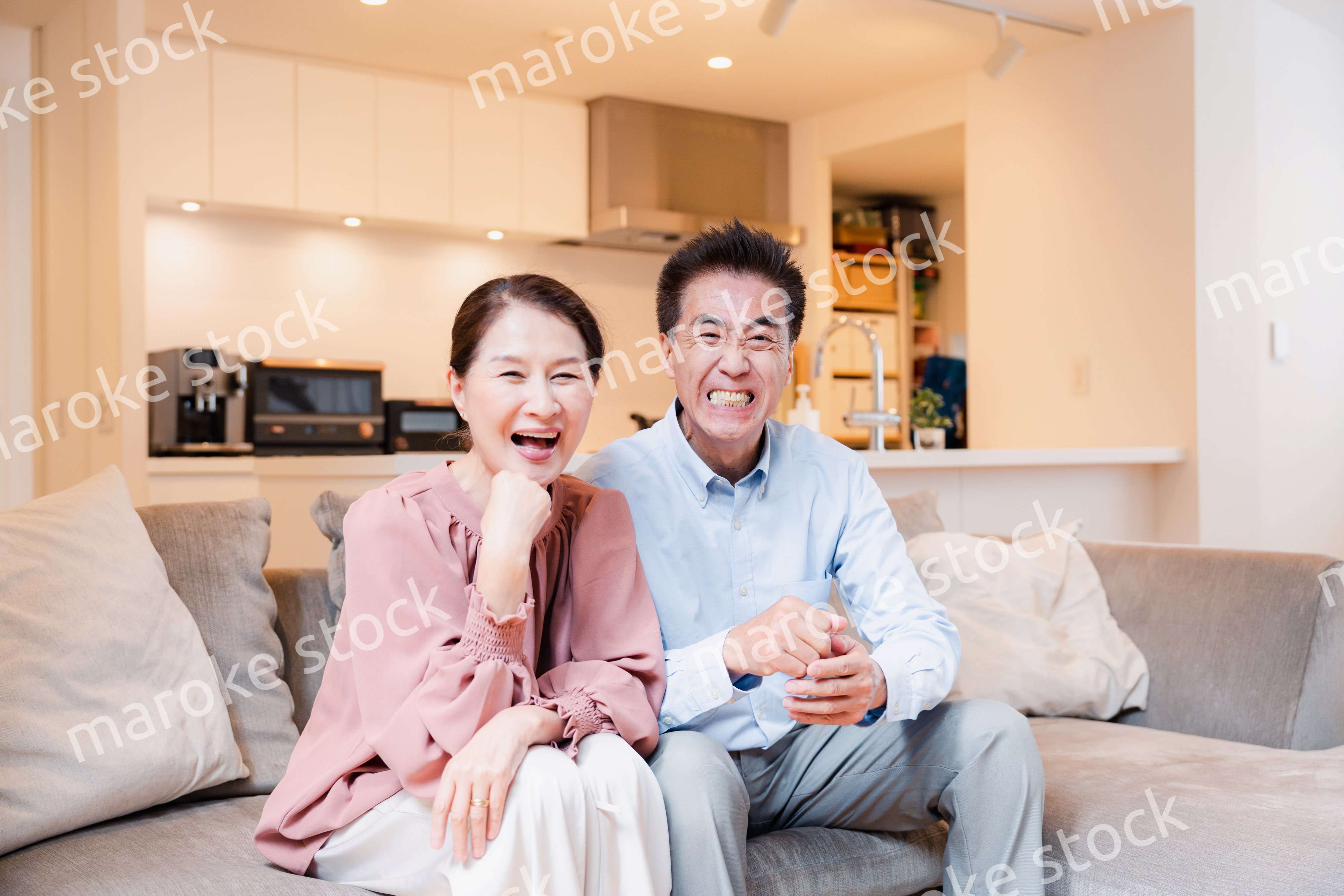 家でテレビを見るシニアの夫婦