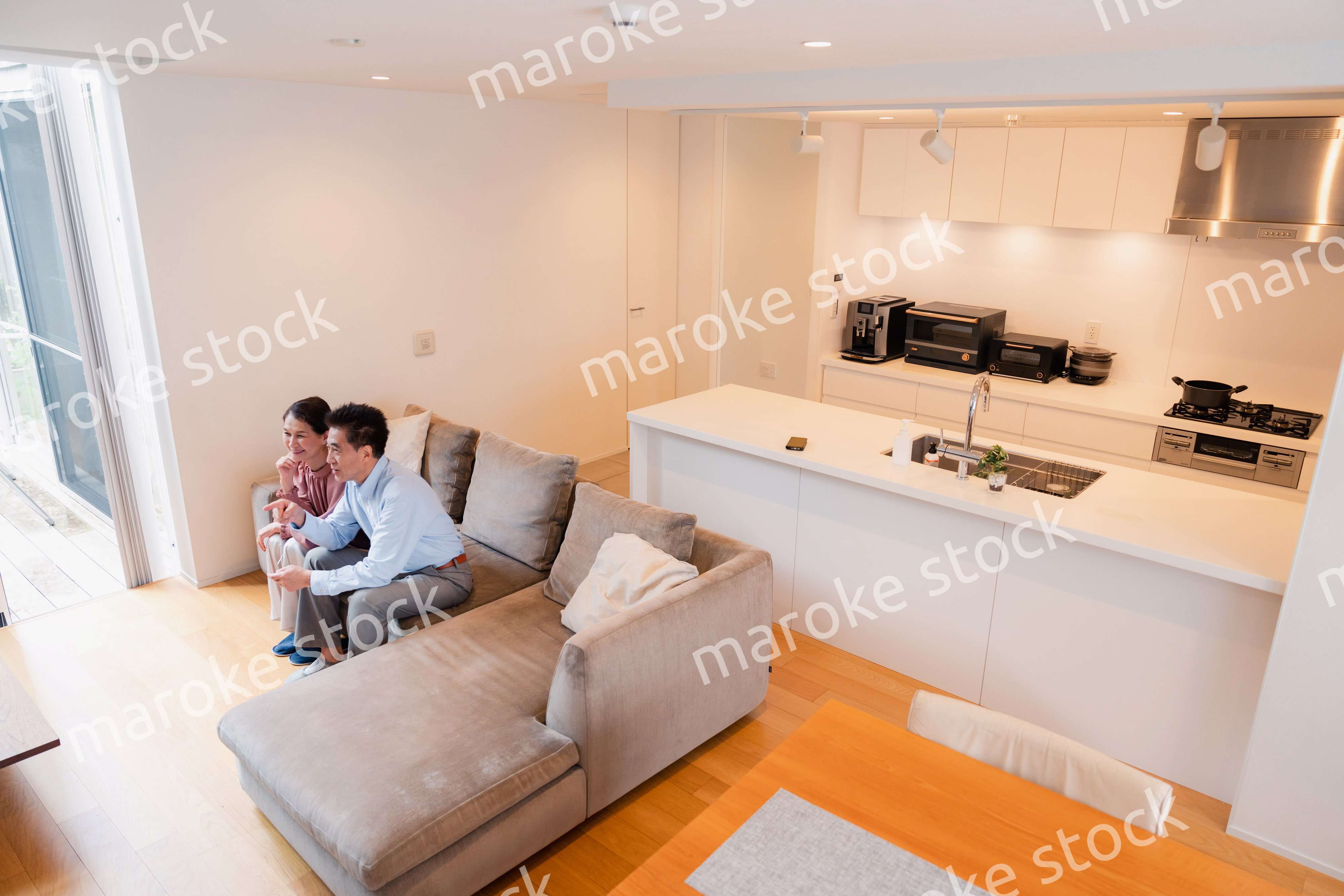 家でテレビを見るシニアの夫婦