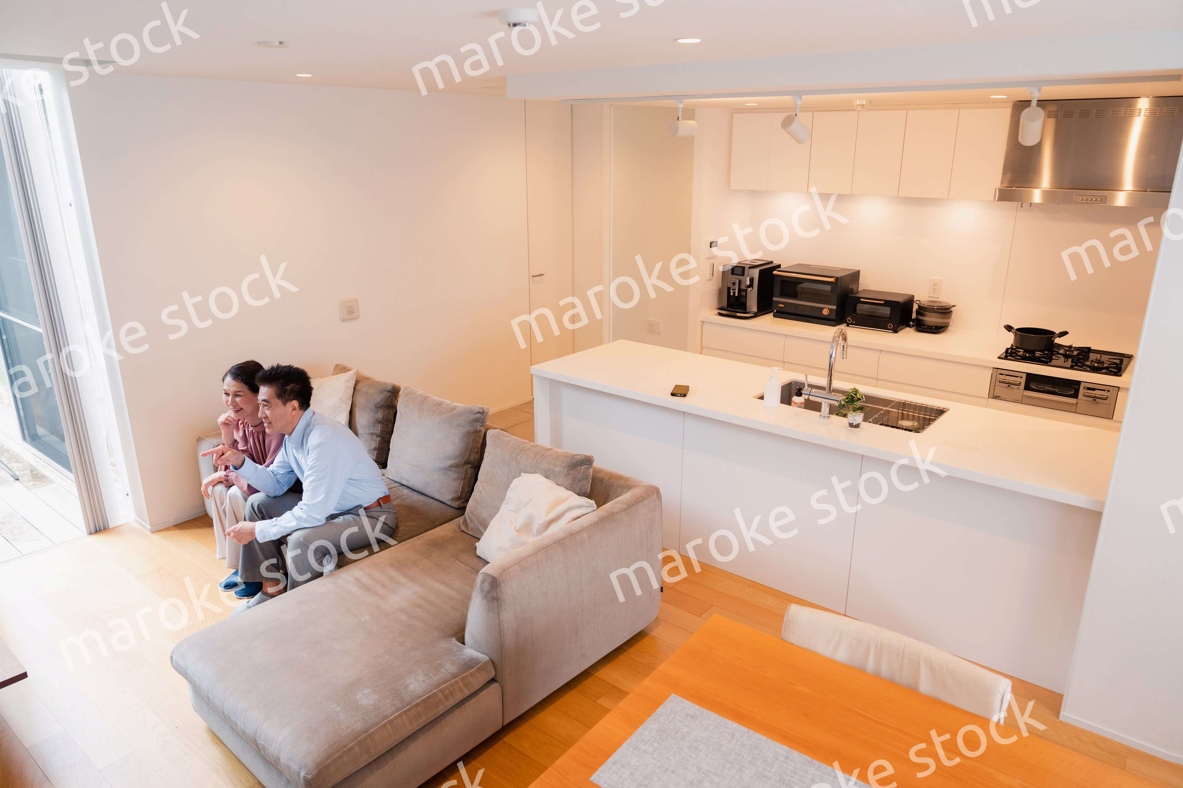 家でテレビを見るシニアの夫婦