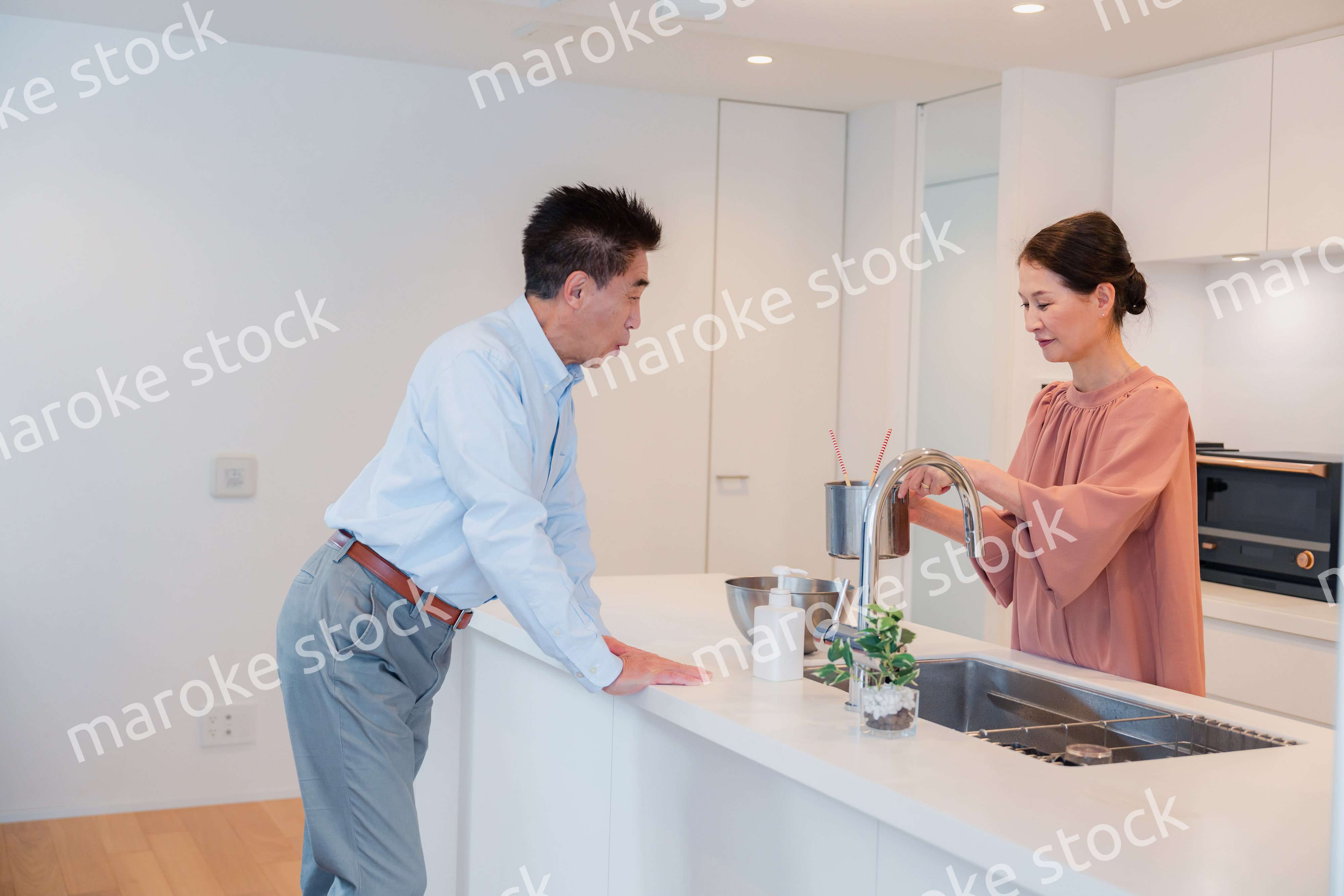 キッチンで一緒にクッキングを楽しむシニアの夫婦