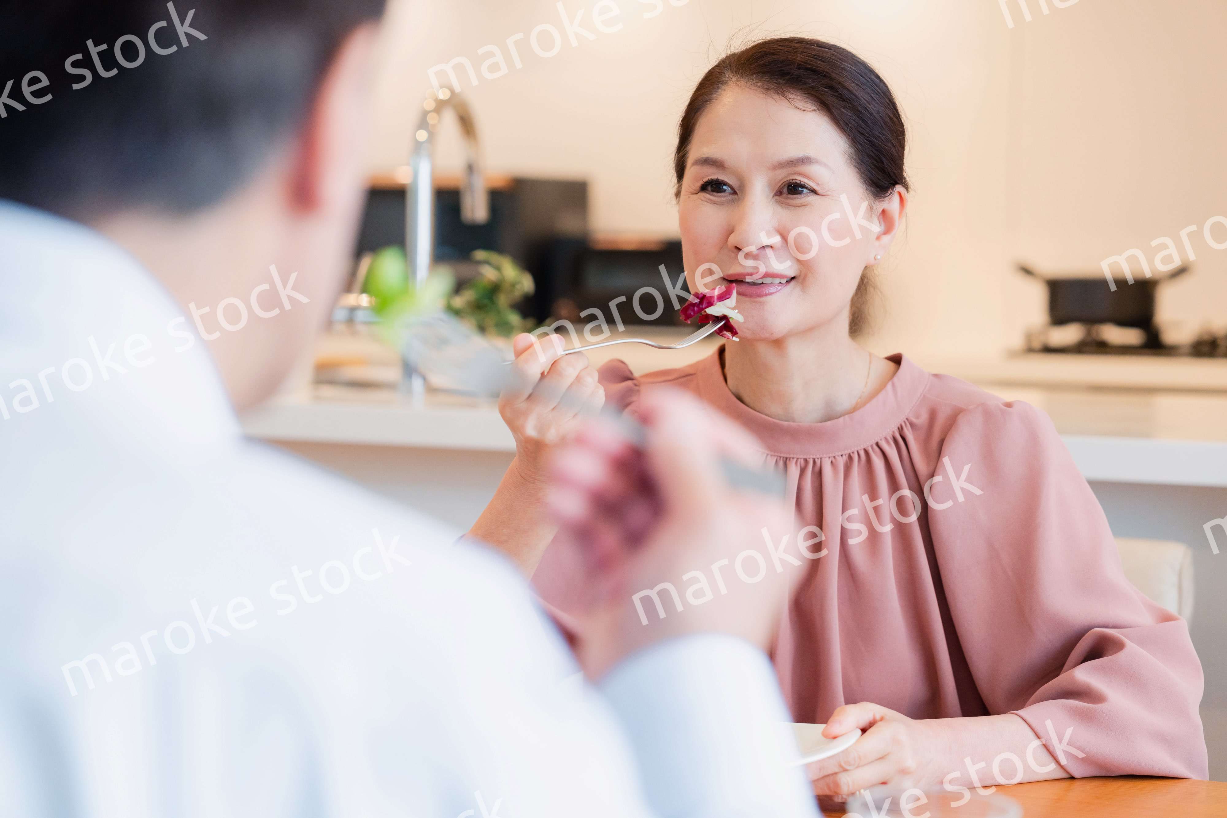 夫婦で楽しくご飯を食べる高齢女性