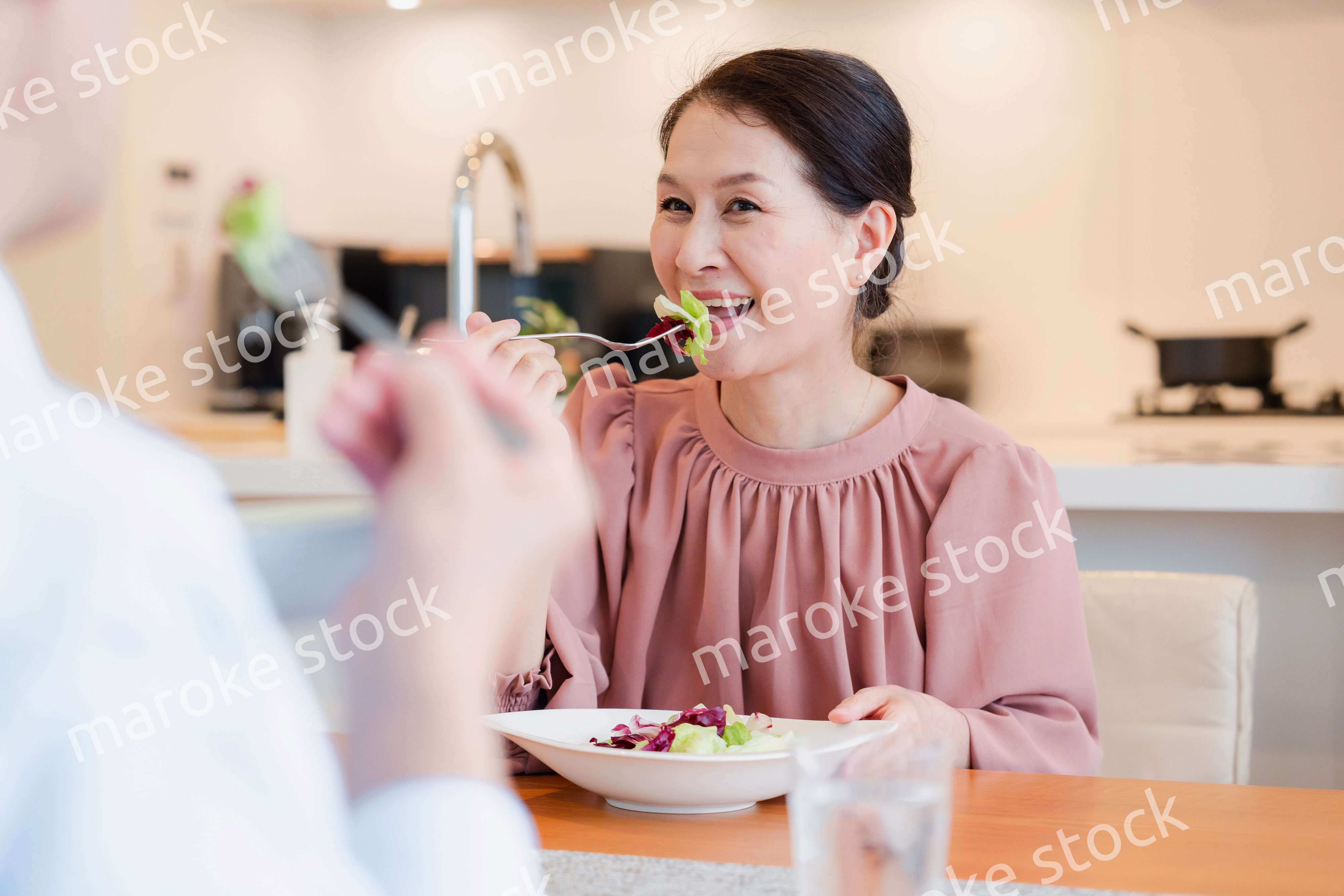夫婦で楽しくご飯を食べる高齢女性
