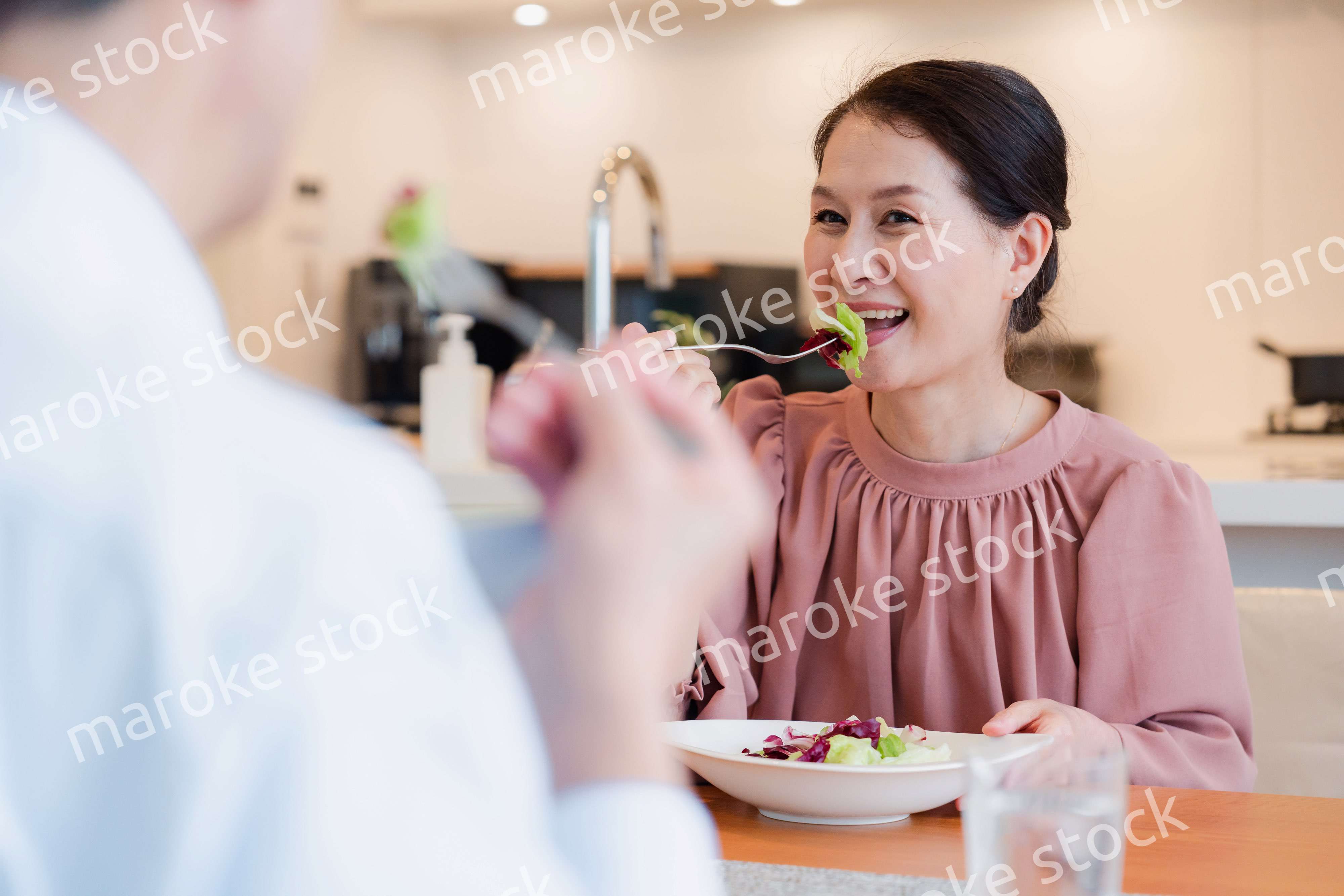 夫婦で楽しくご飯を食べる高齢女性