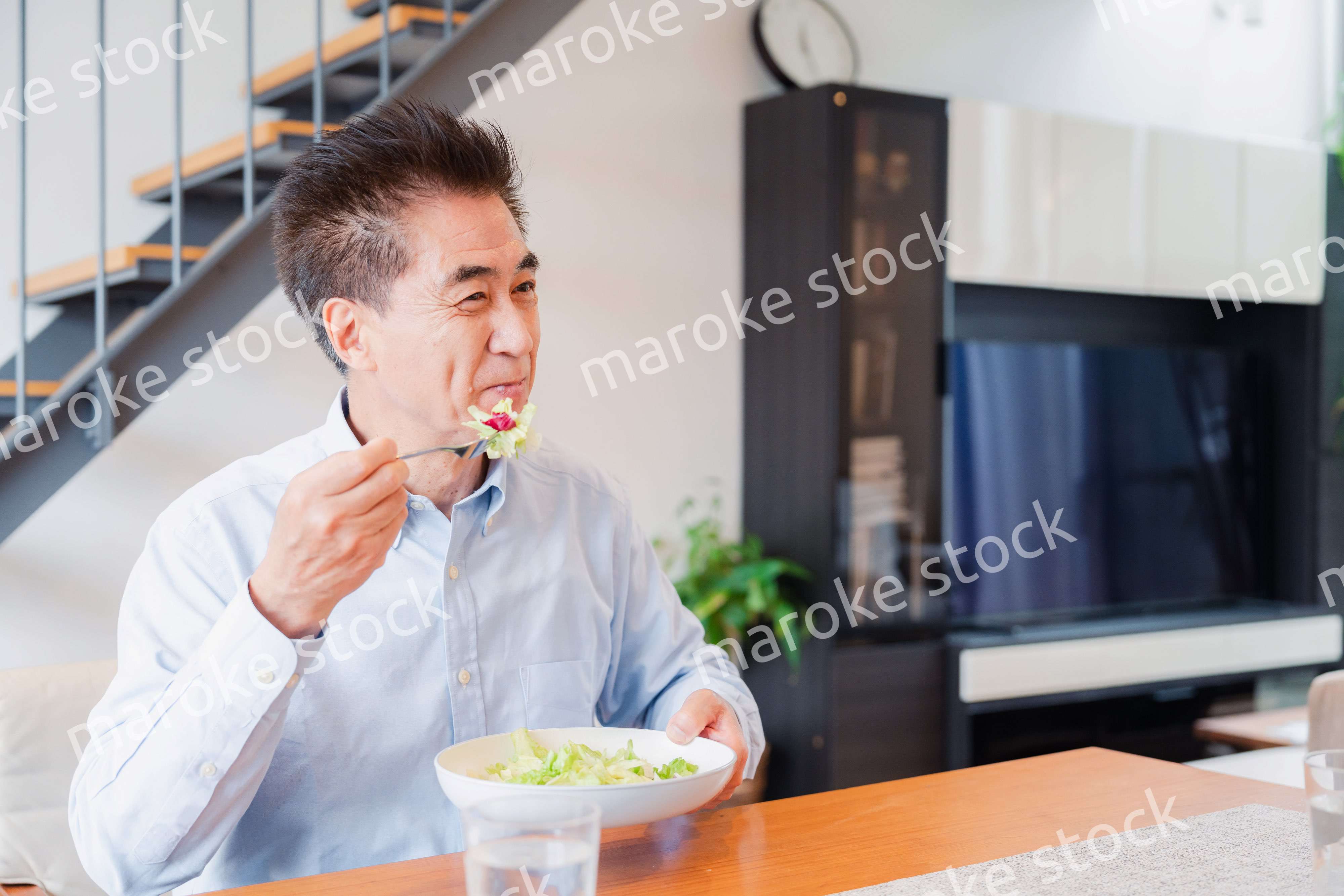 サラダをおいしく食べる高齢の男性
