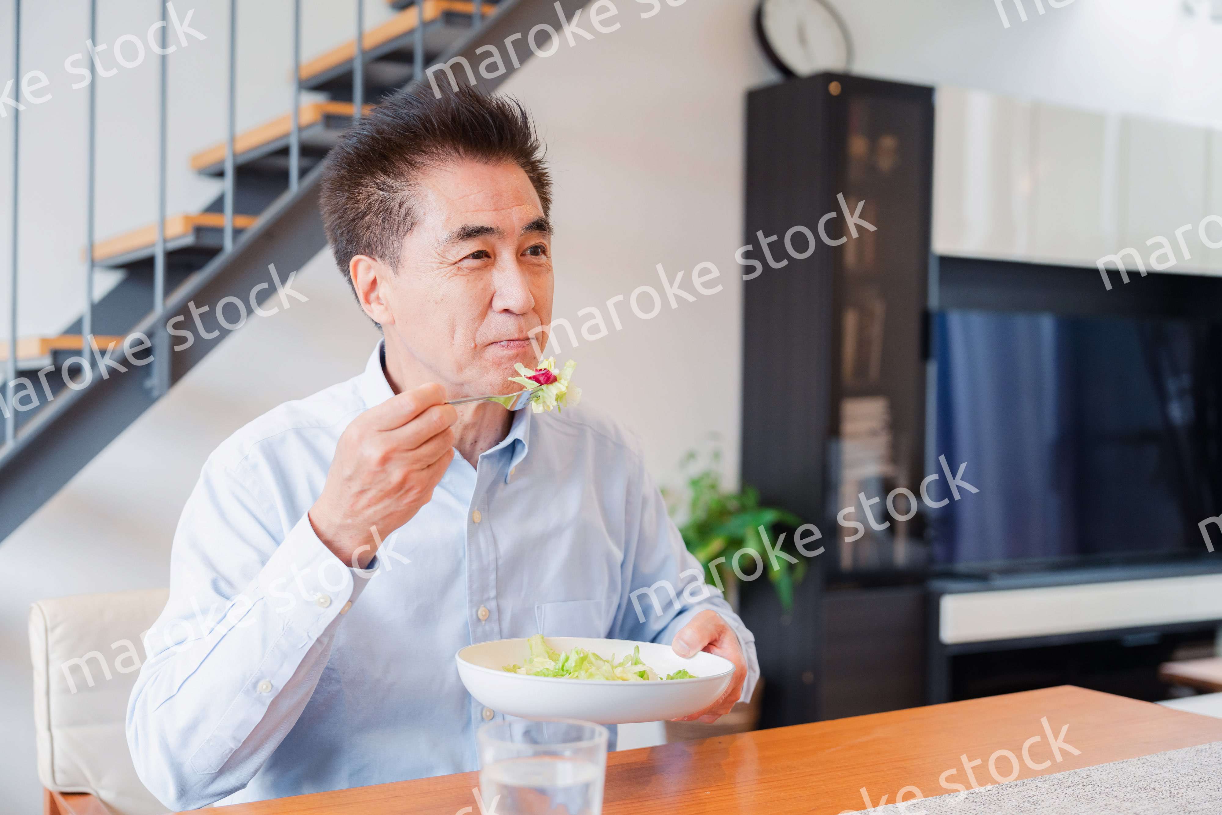 サラダをおいしく食べる高齢の男性