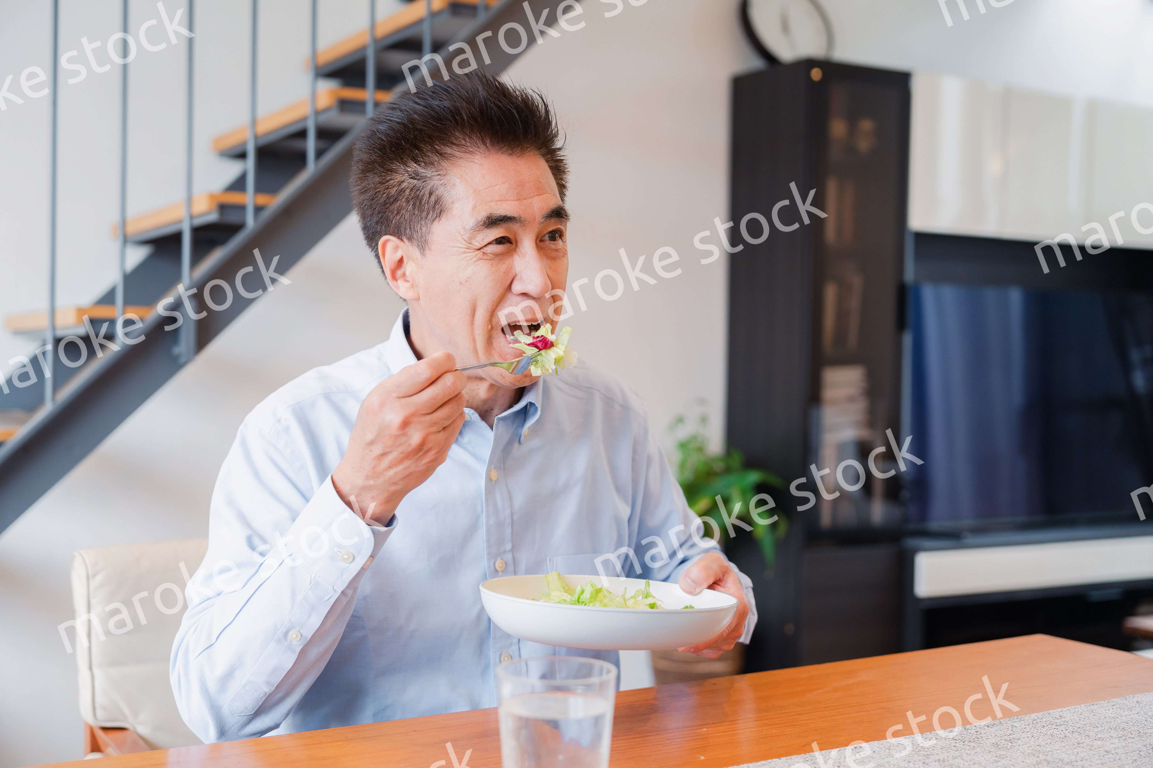 サラダをおいしく食べる高齢の男性