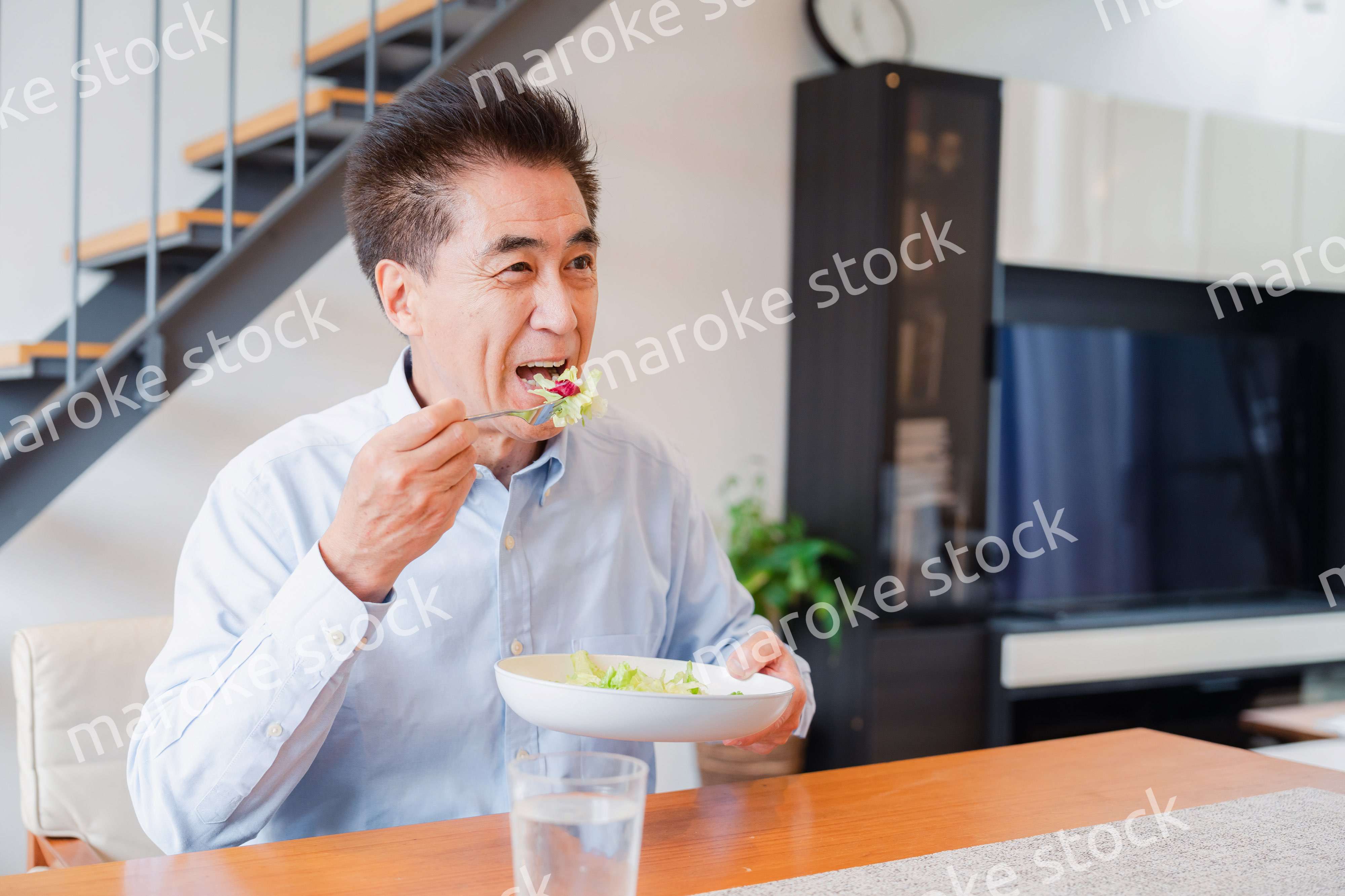 サラダをおいしく食べる高齢の男性