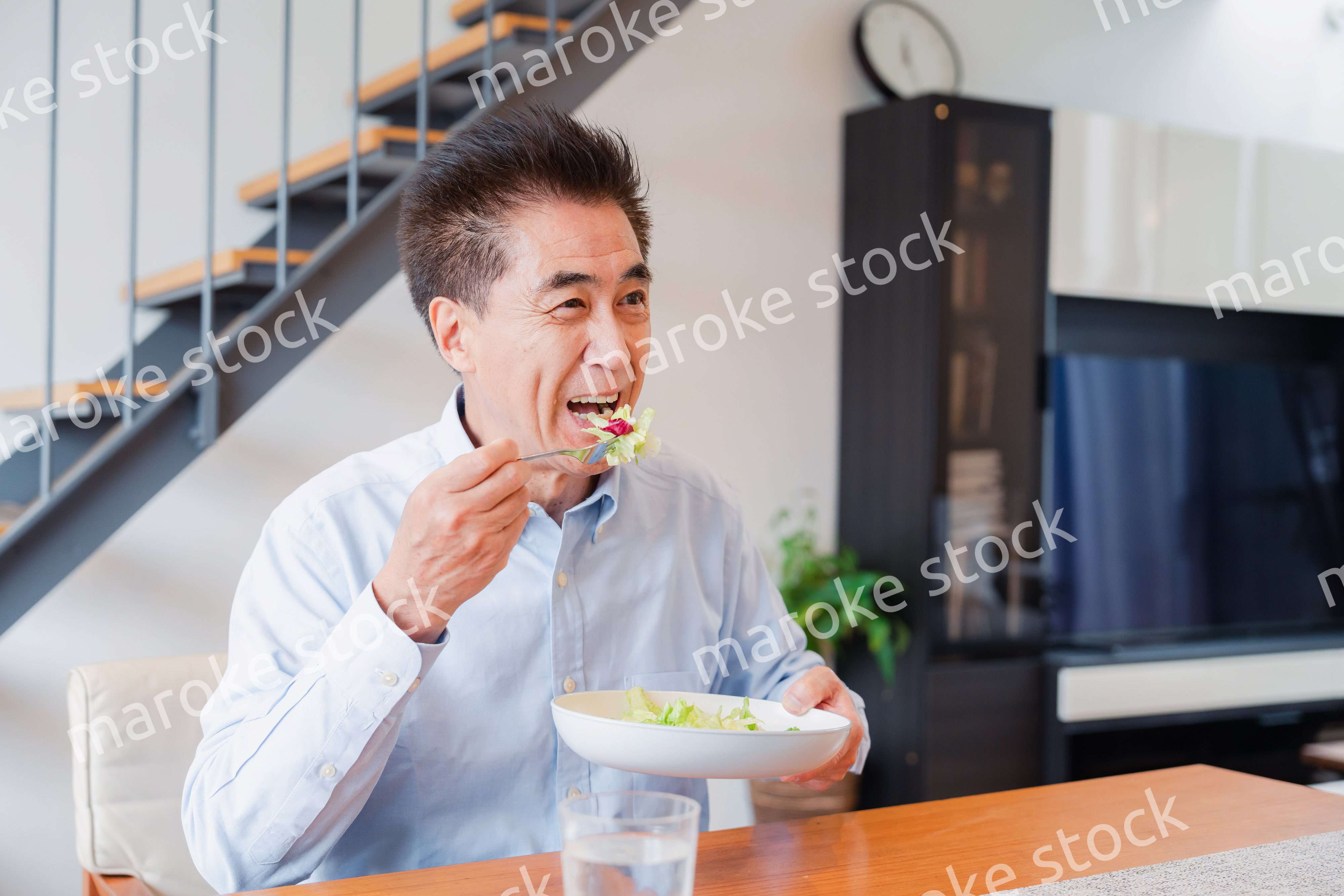 サラダをおいしく食べる高齢の男性