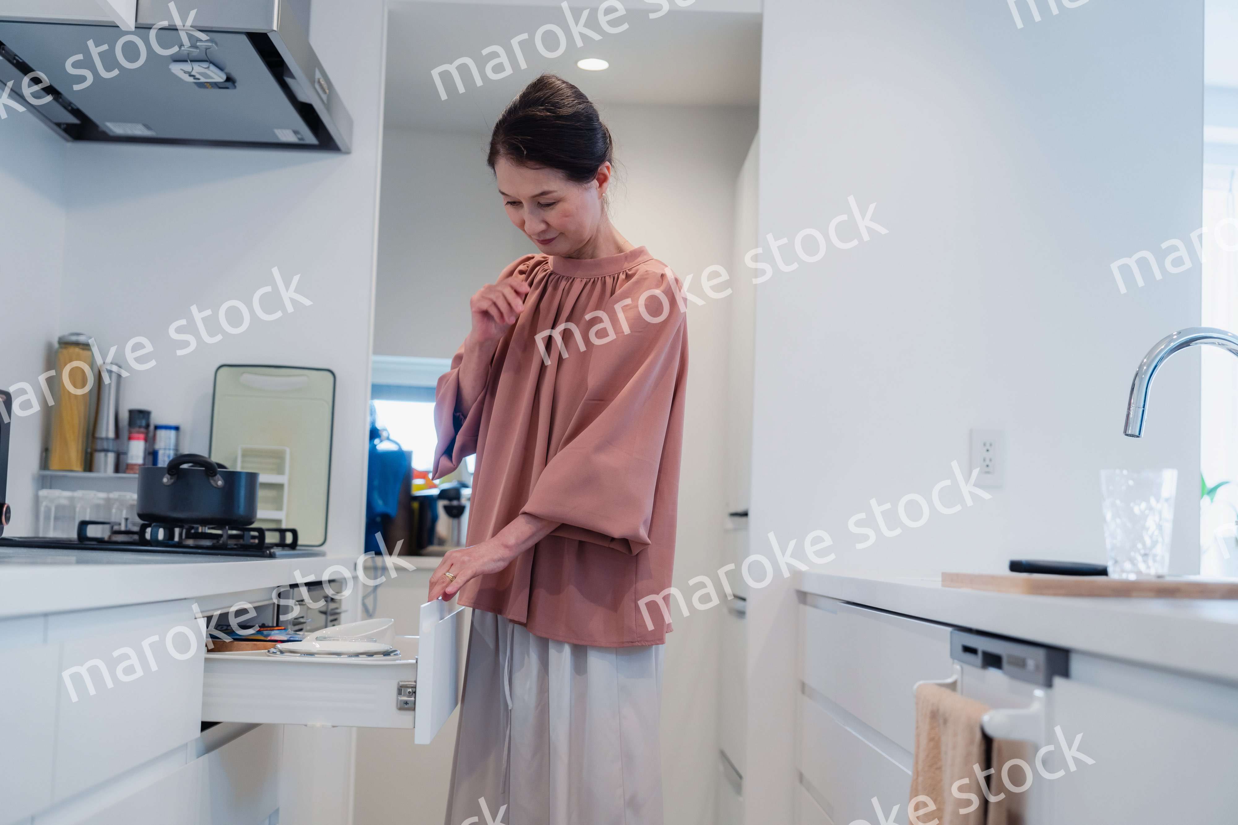 キッチンの収納を工夫するシニアの女性