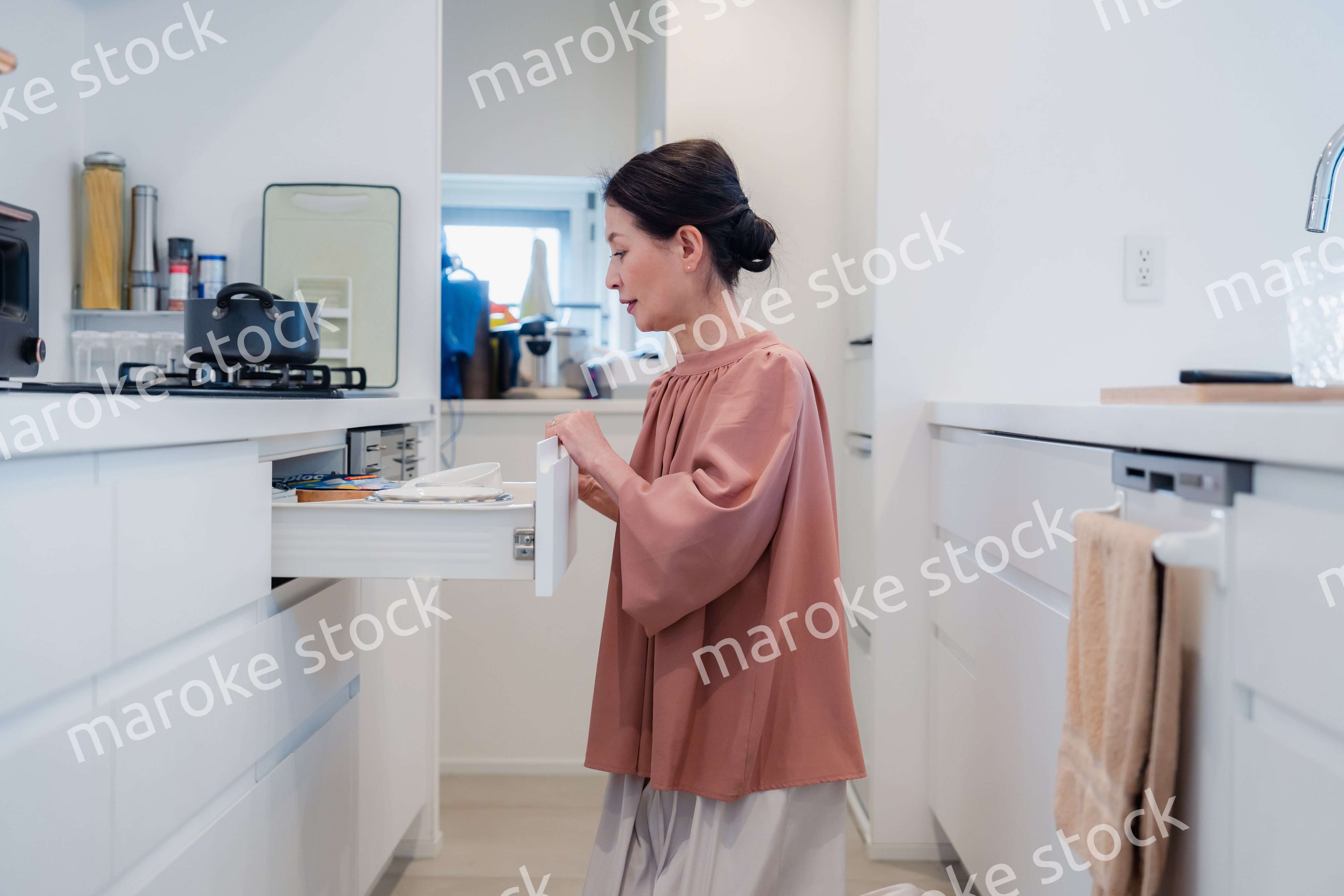 キッチンの収納を工夫するシニアの女性