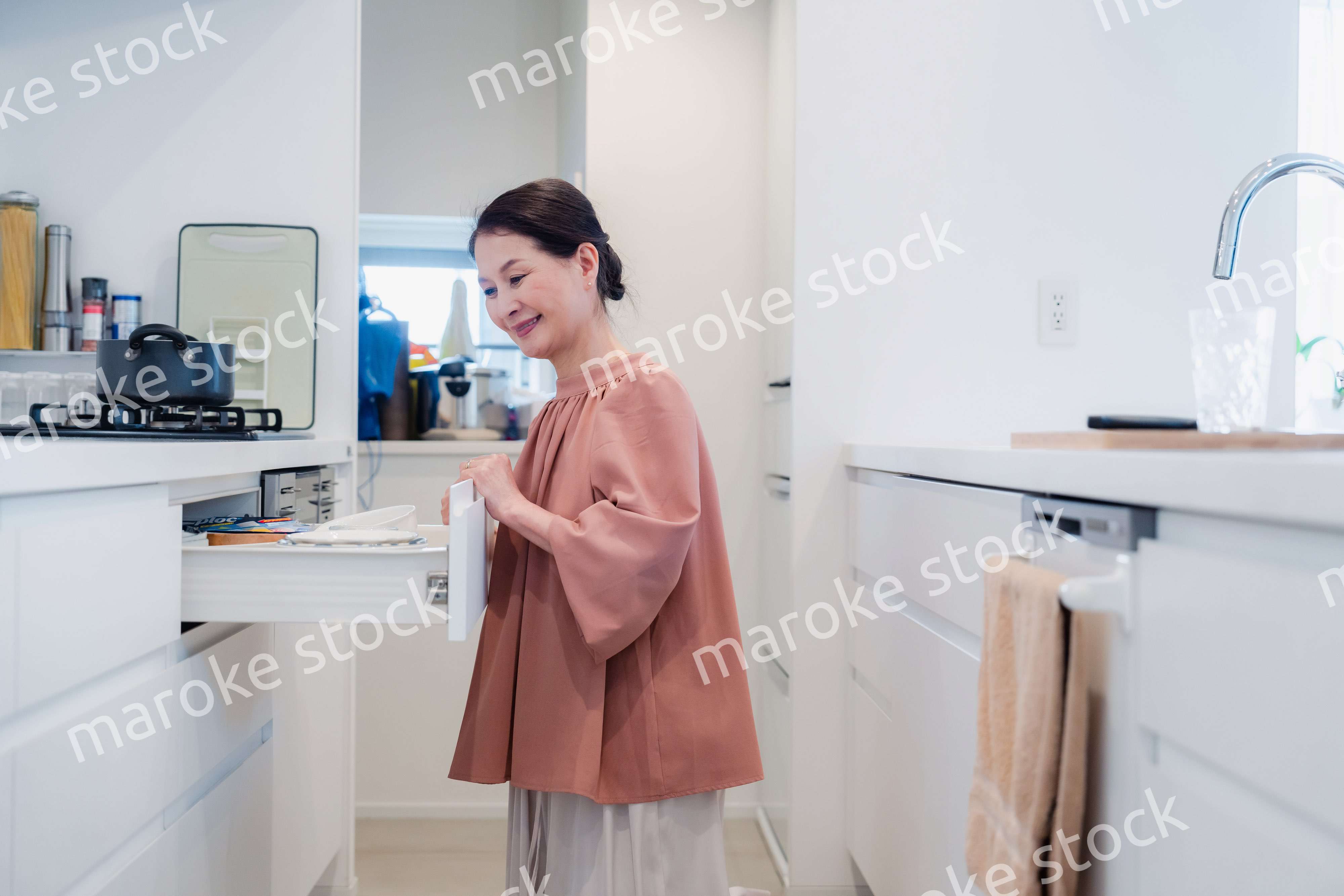 キッチンの収納を工夫するシニアの女性