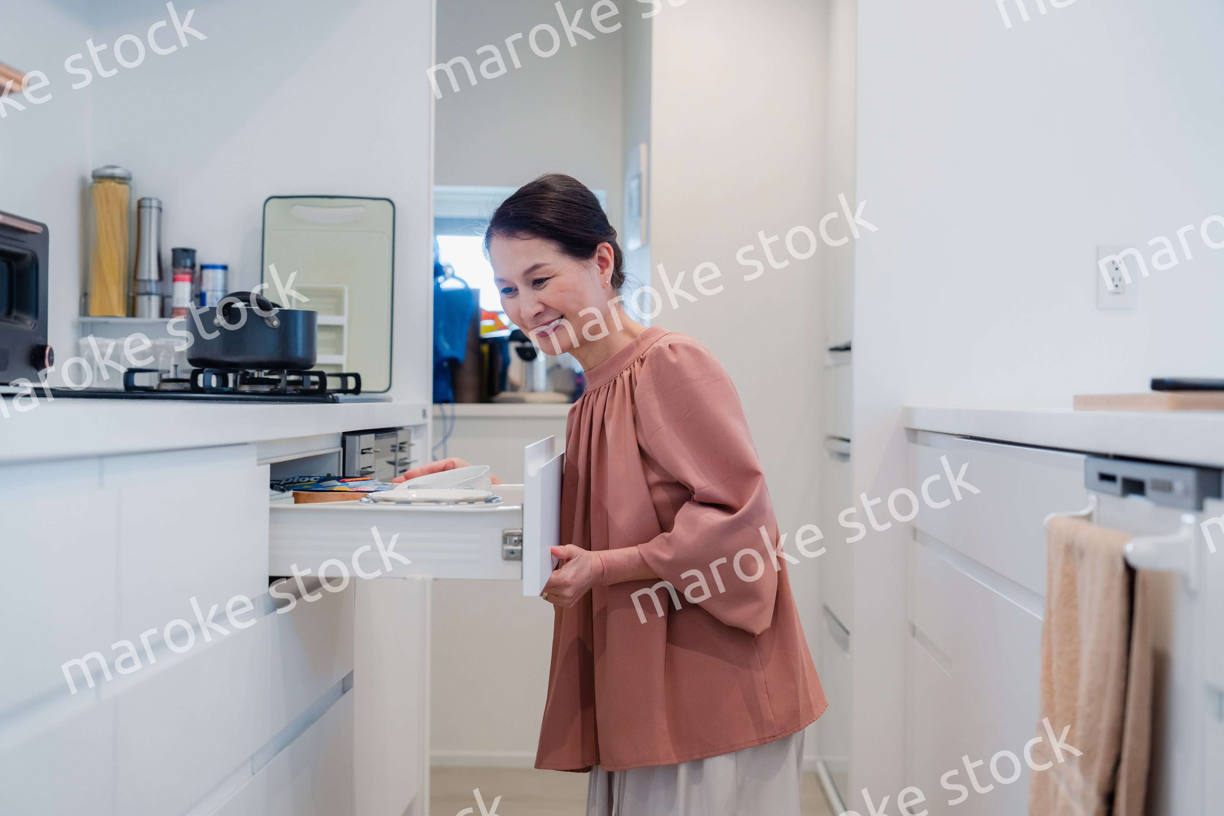 キッチンの収納を工夫するシニアの女性