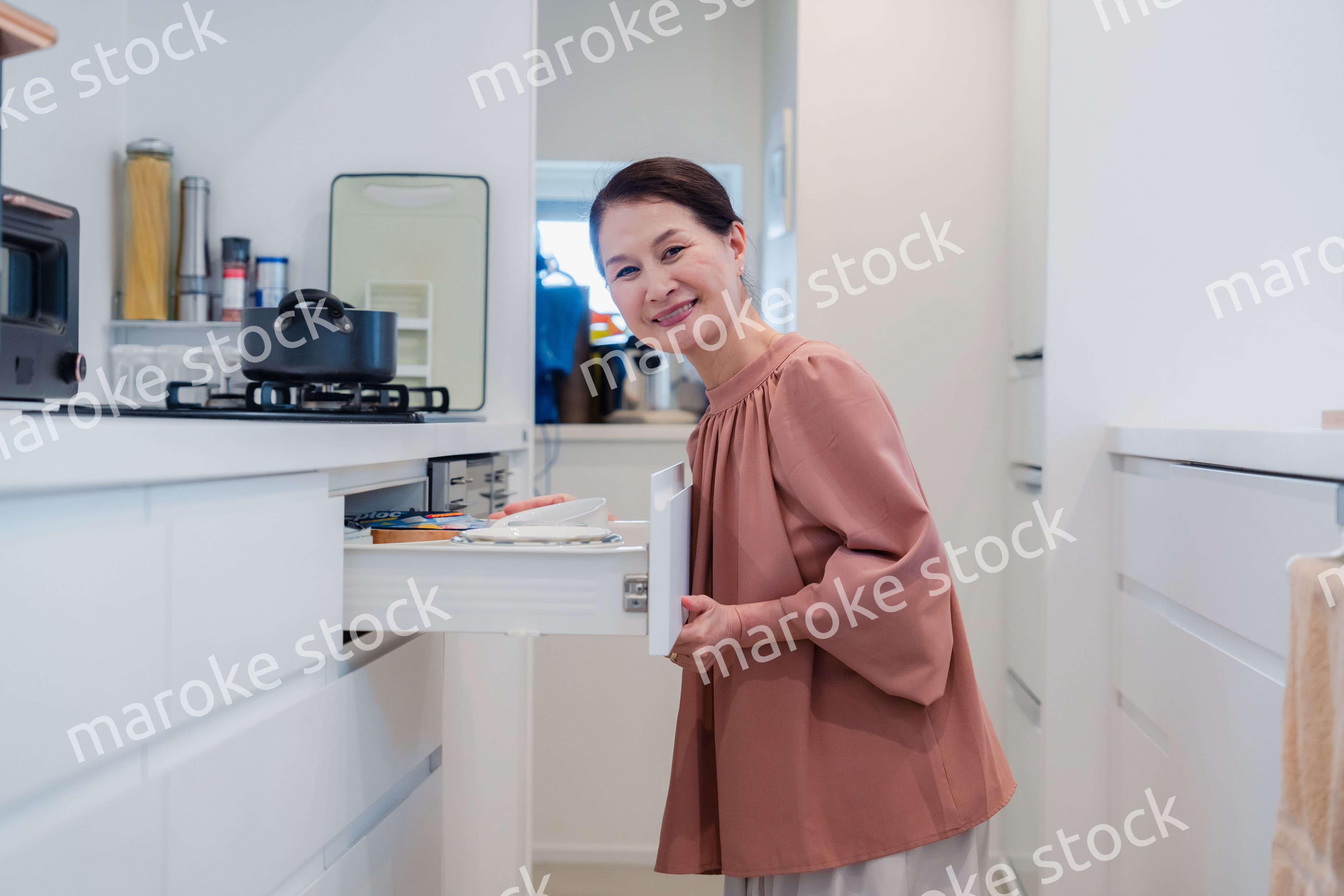 キッチンの収納を工夫するシニアの女性