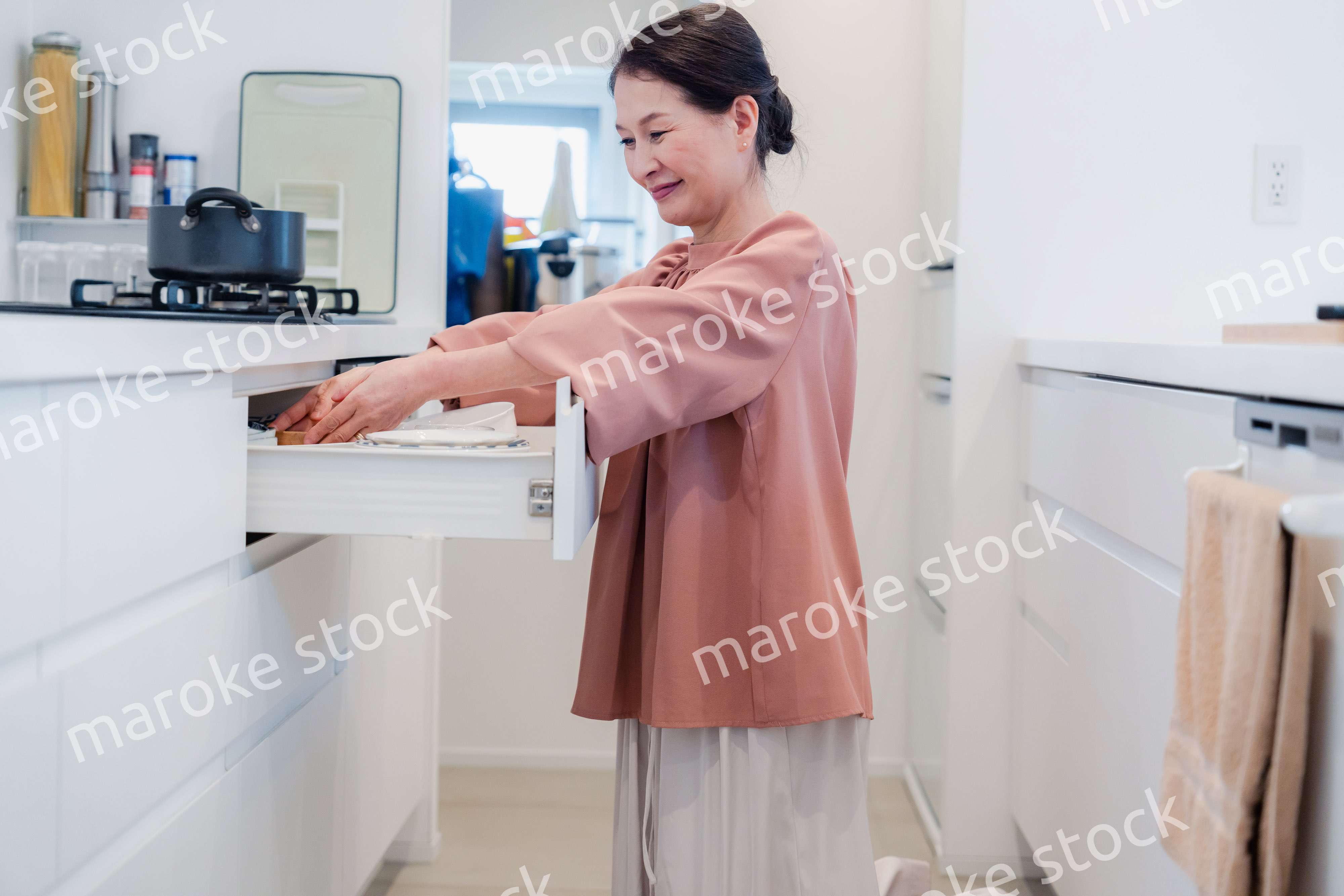 キッチンの収納を工夫するシニアの女性