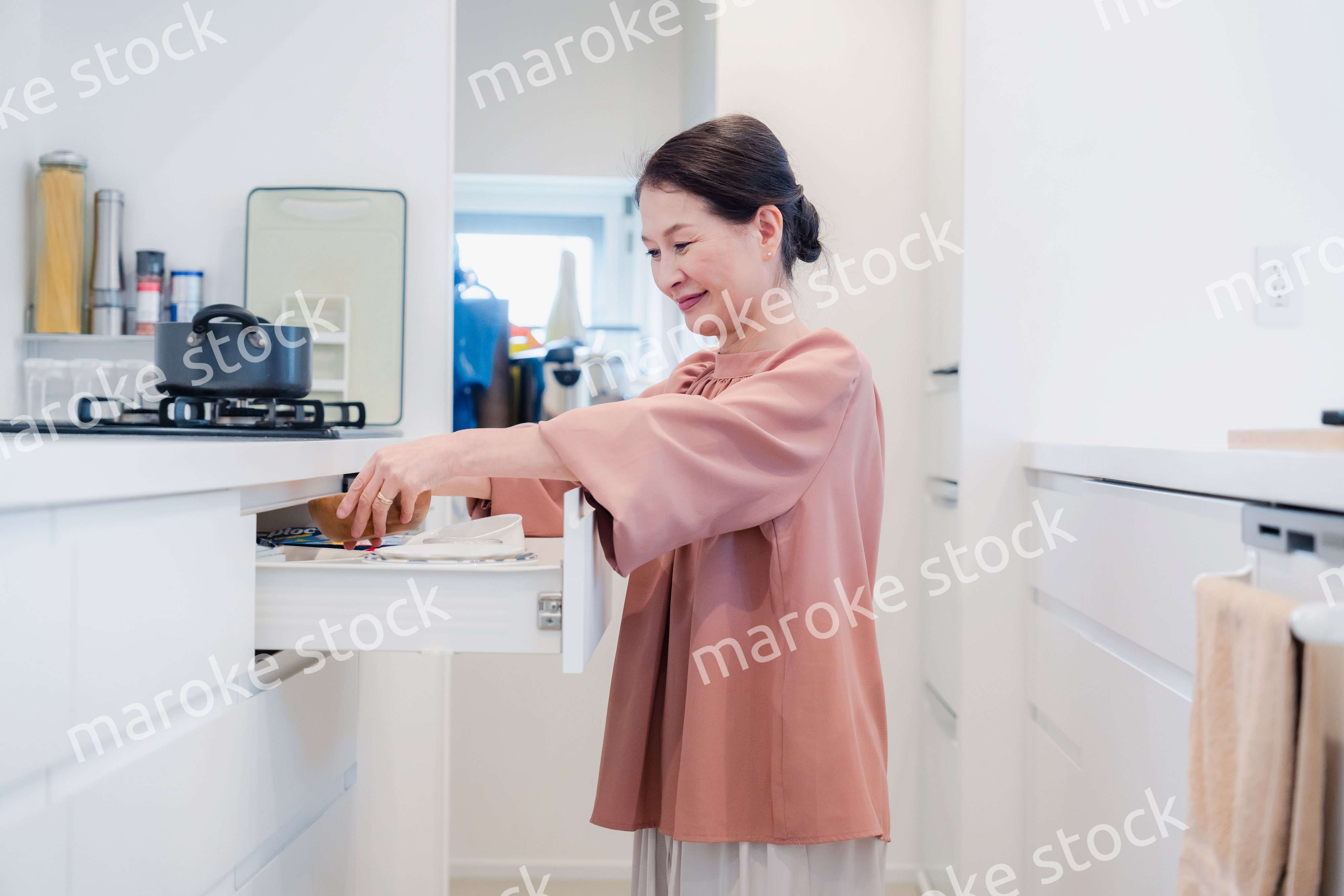 キッチンの収納を工夫するシニアの女性