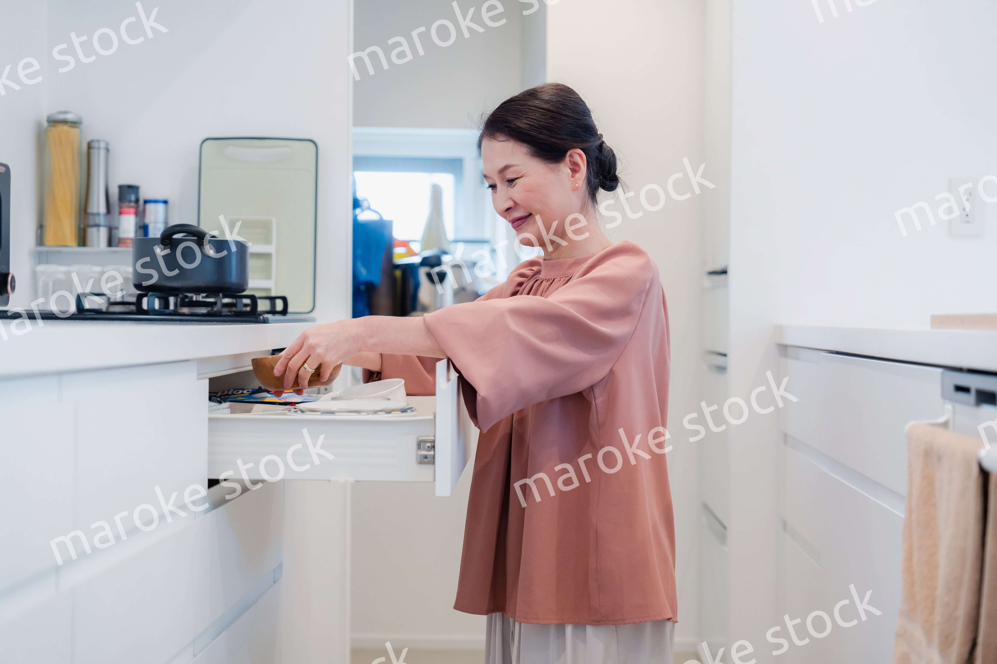 キッチンの収納を工夫するシニアの女性