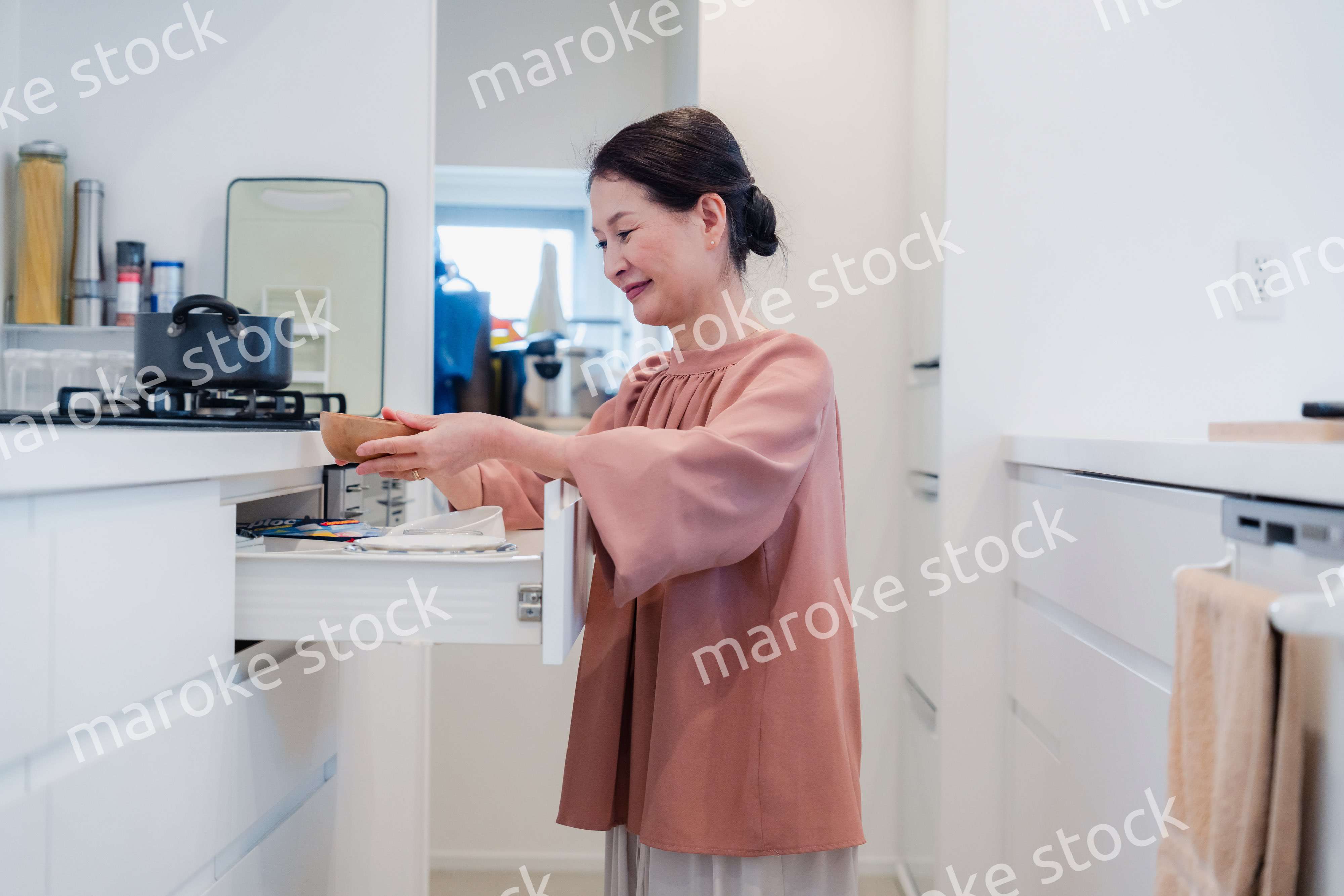 キッチンの収納を工夫するシニアの女性