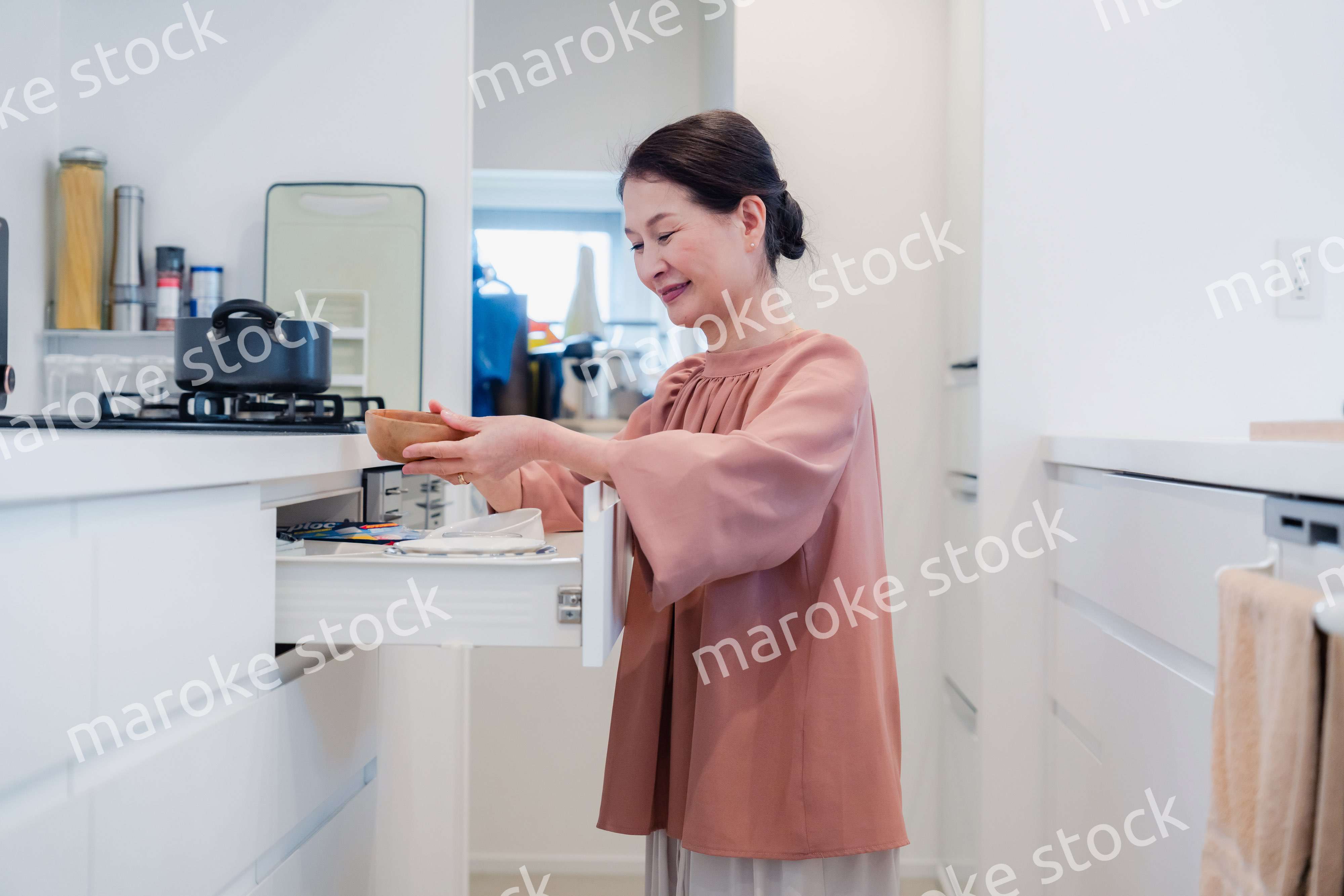 キッチンの収納を工夫するシニアの女性