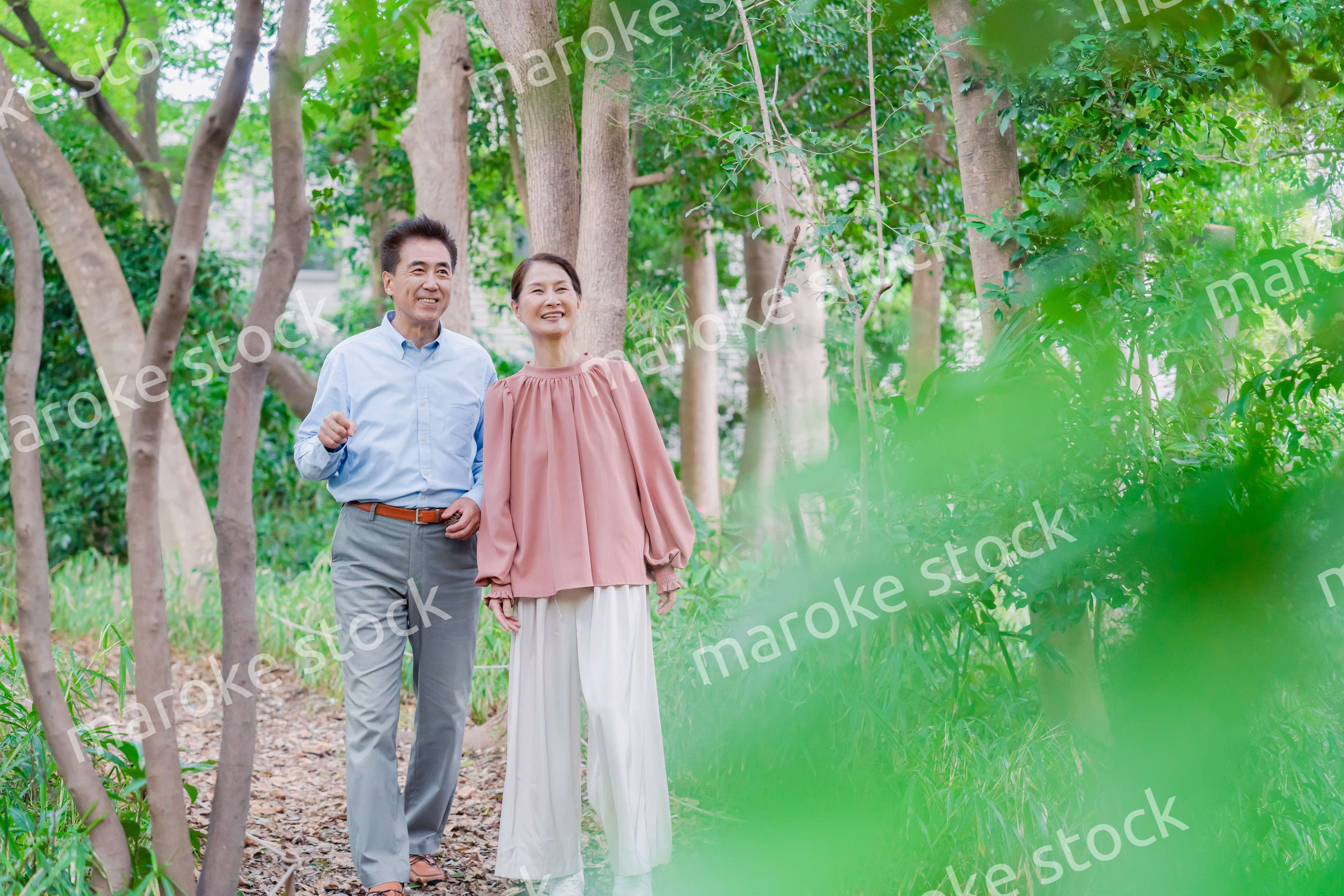 自然の中を散歩するシニアの夫婦