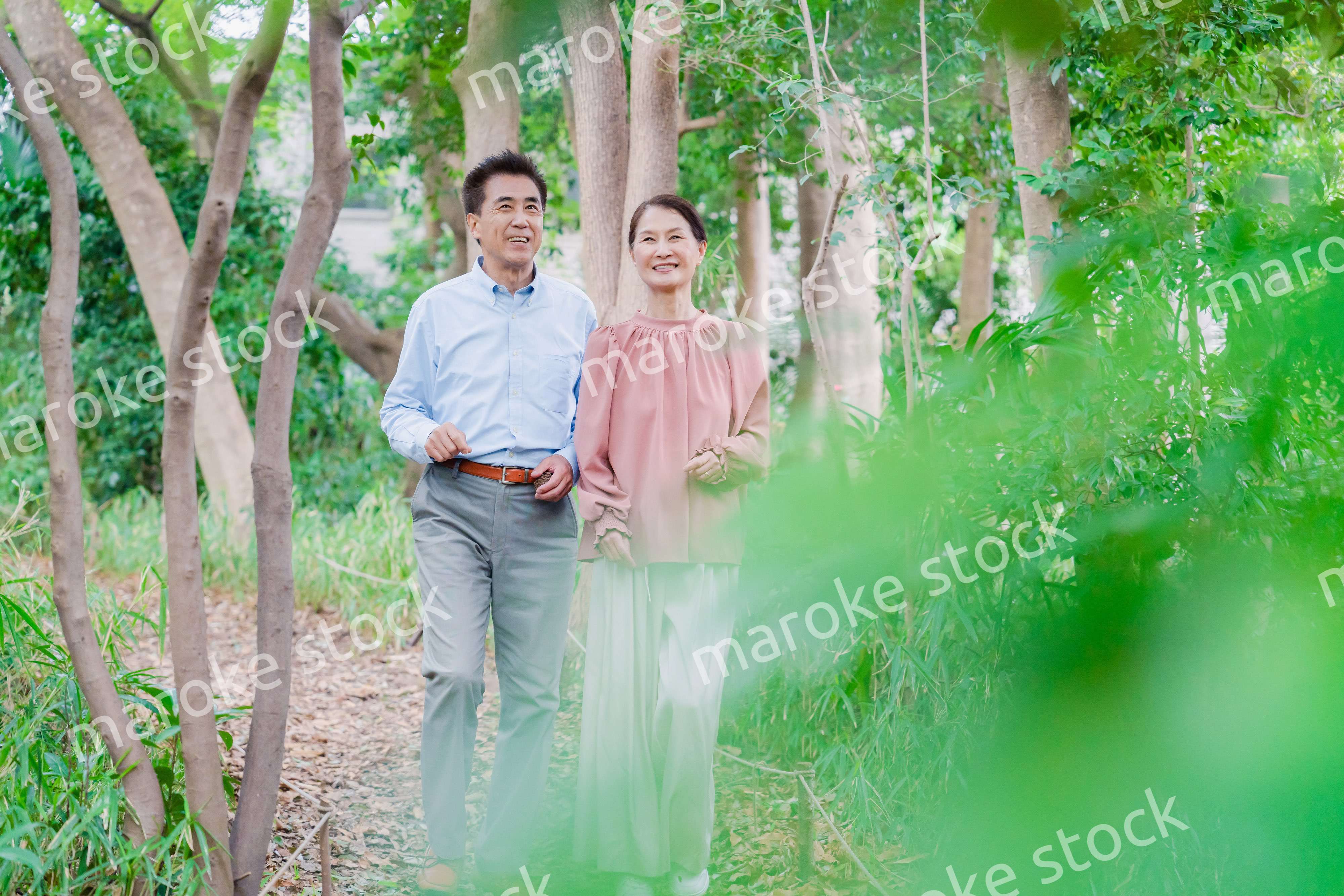 自然の中を散歩するシニアの夫婦