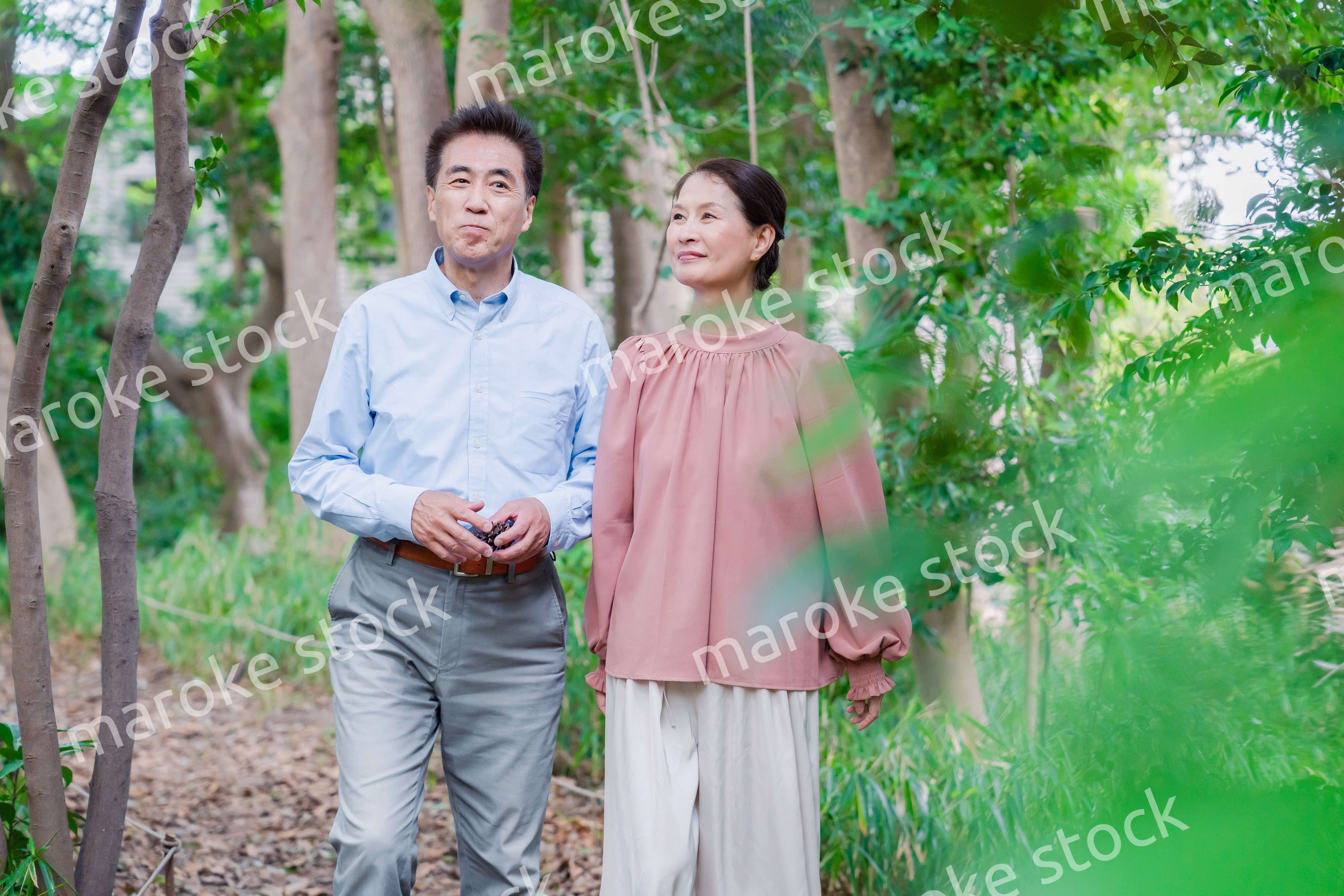 自然の中を散歩するシニアの夫婦