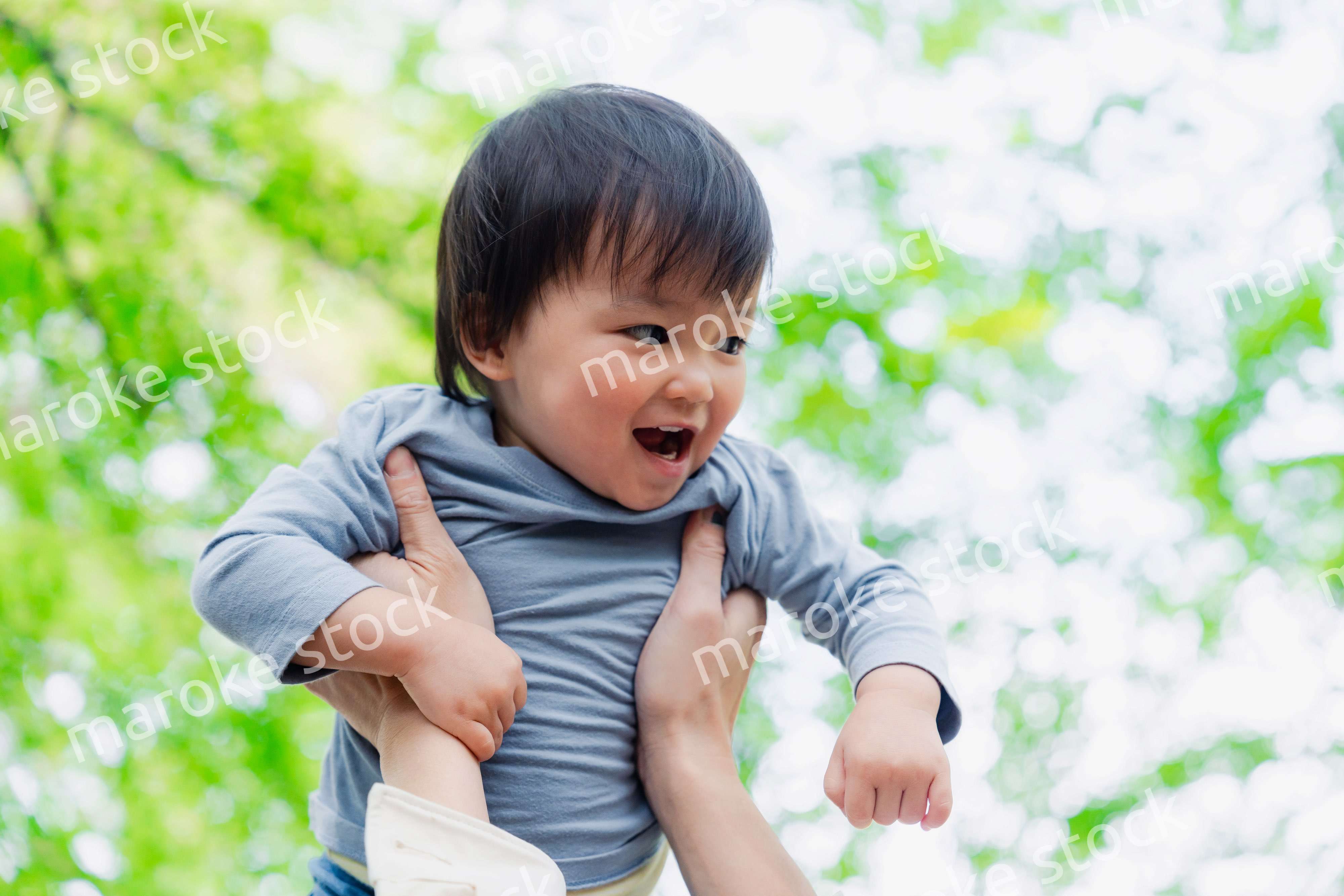 高い高いをされて喜ぶ男の子の赤ちゃん