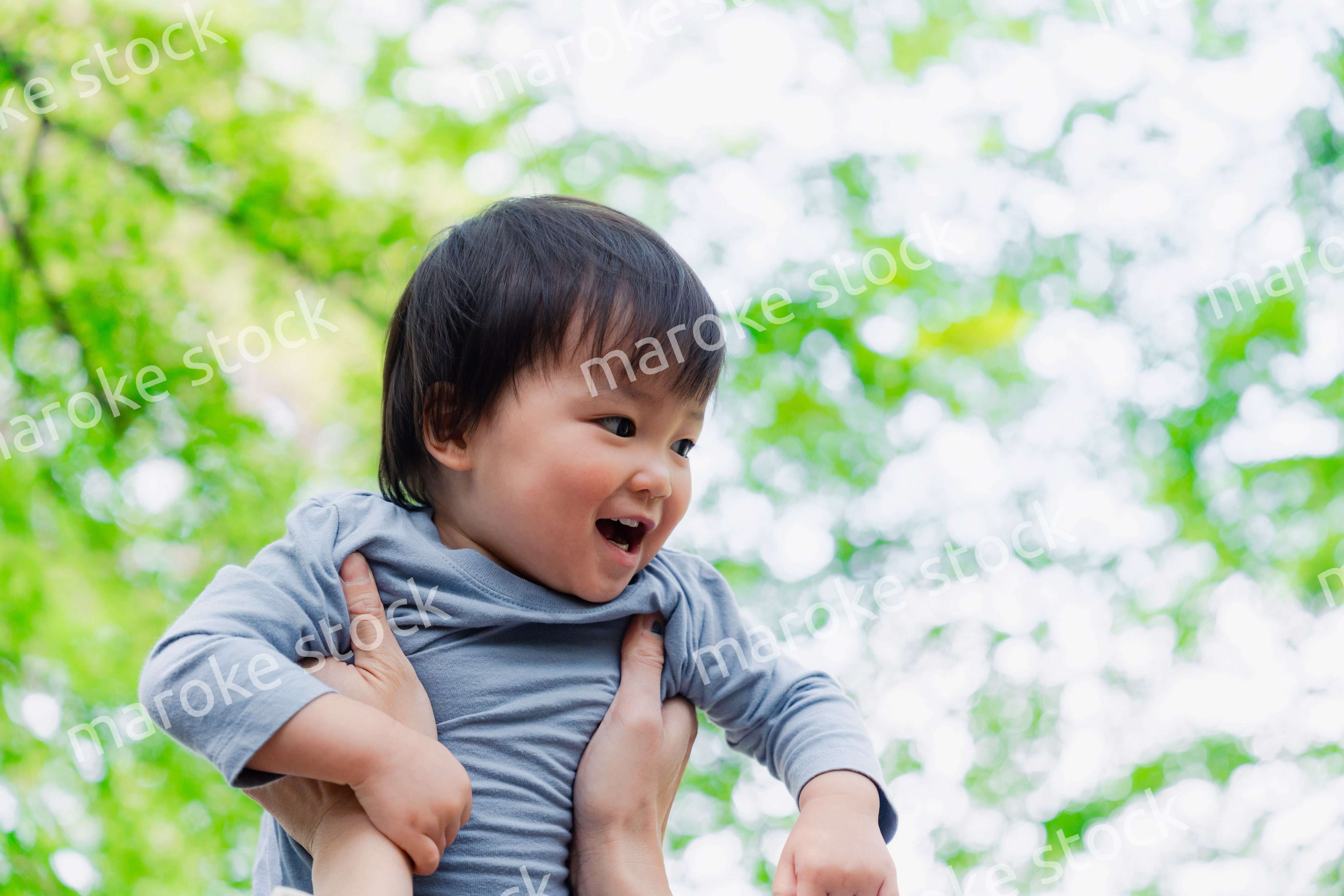 高い高いをされて喜ぶ男の子の赤ちゃん