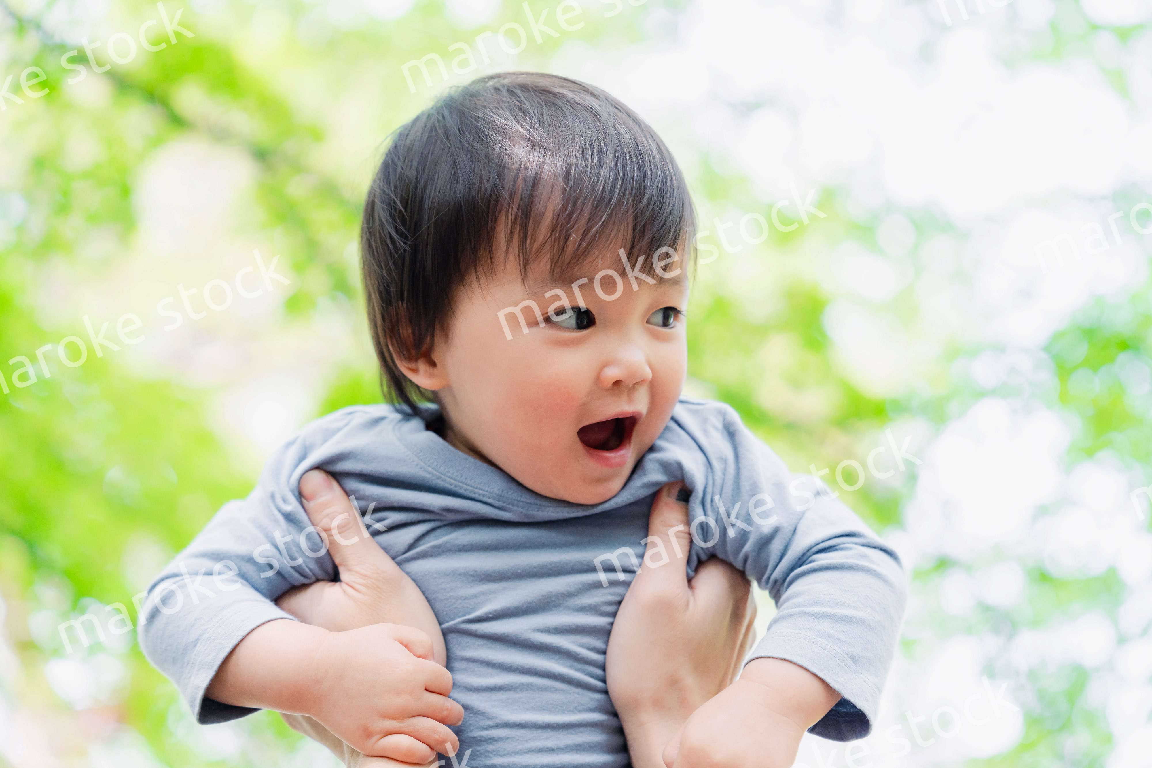 高い高いをされて喜ぶ男の子の赤ちゃん