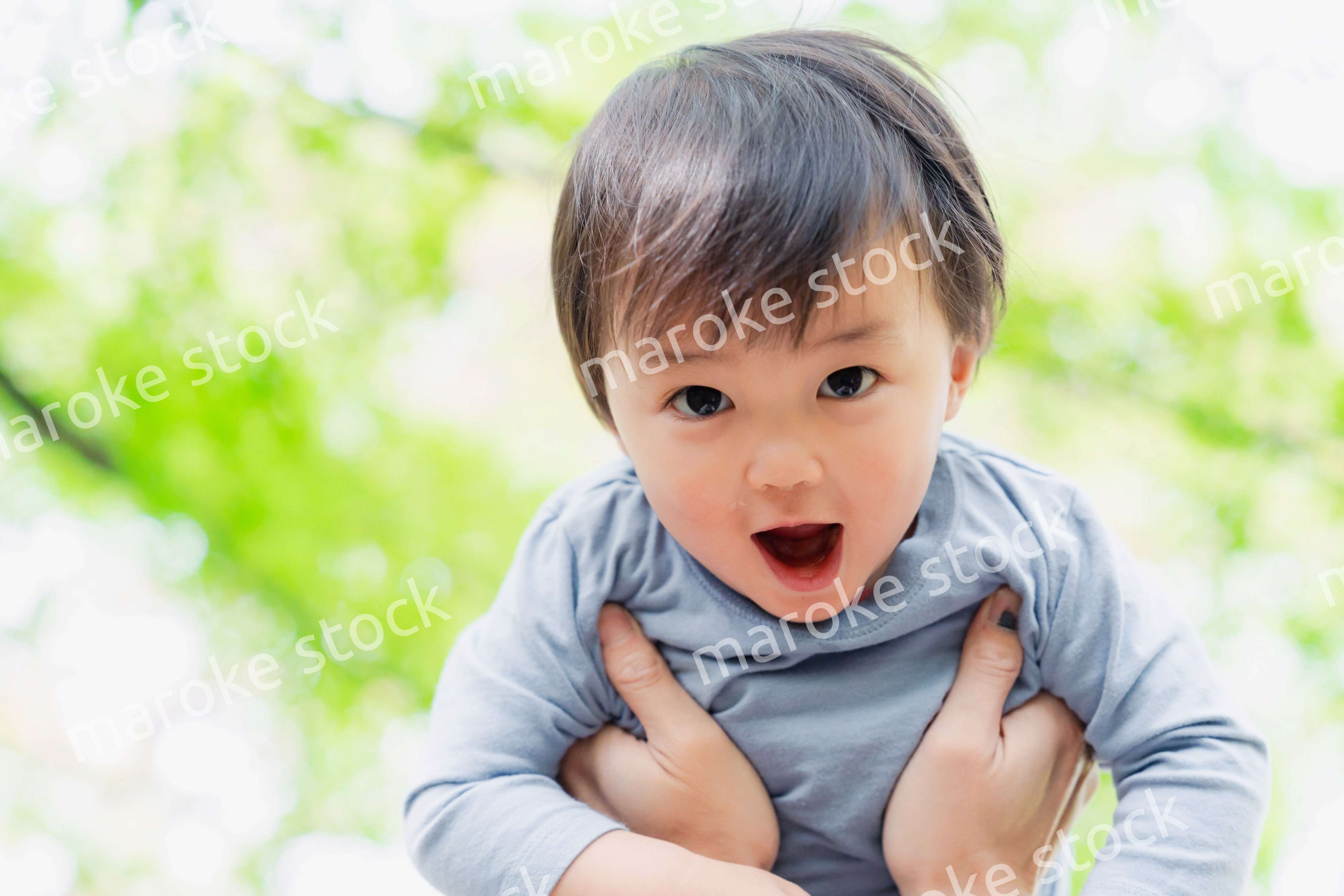 高い高いをされて喜ぶ男の子の赤ちゃん