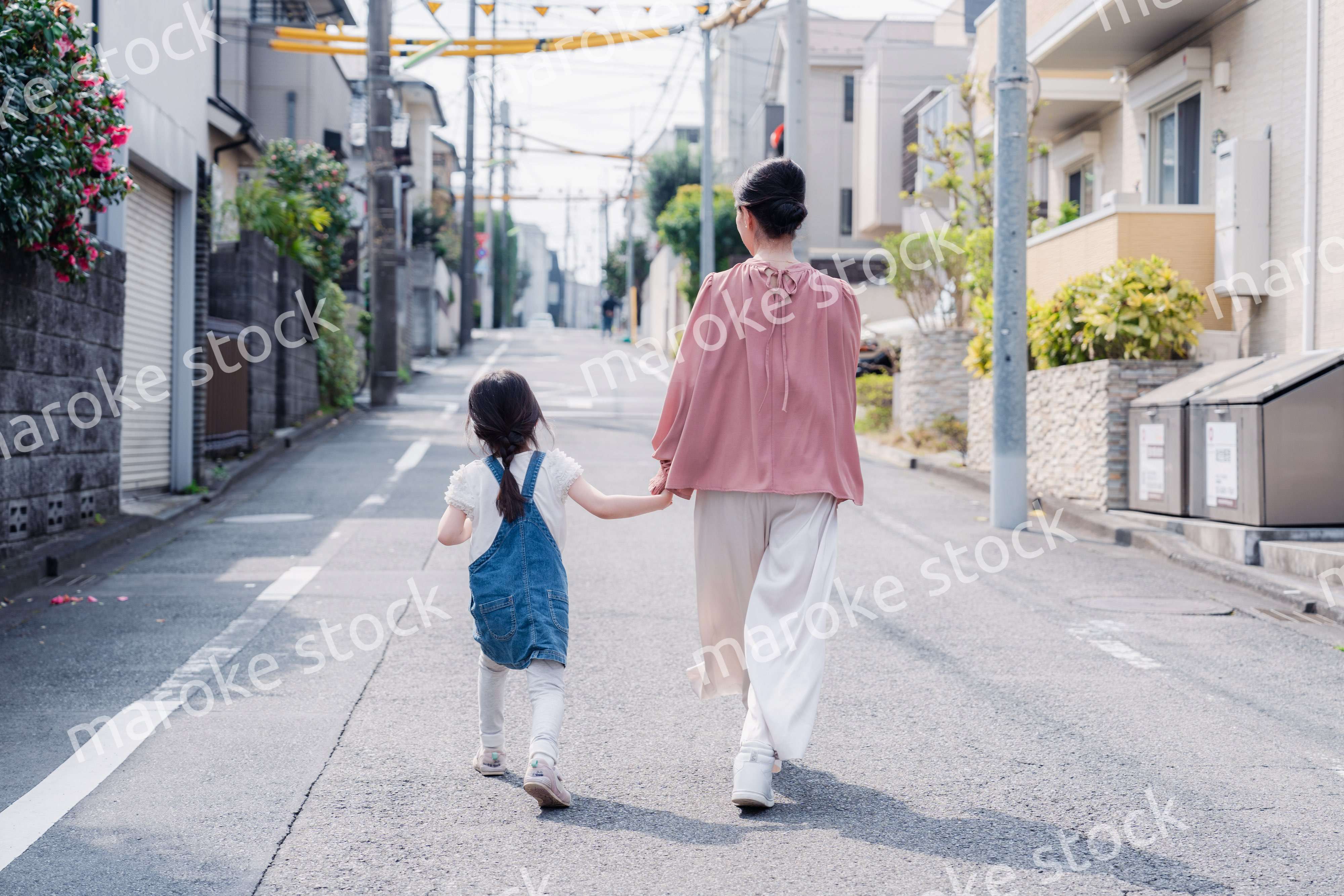 おばあちゃんと街を散歩する女の子