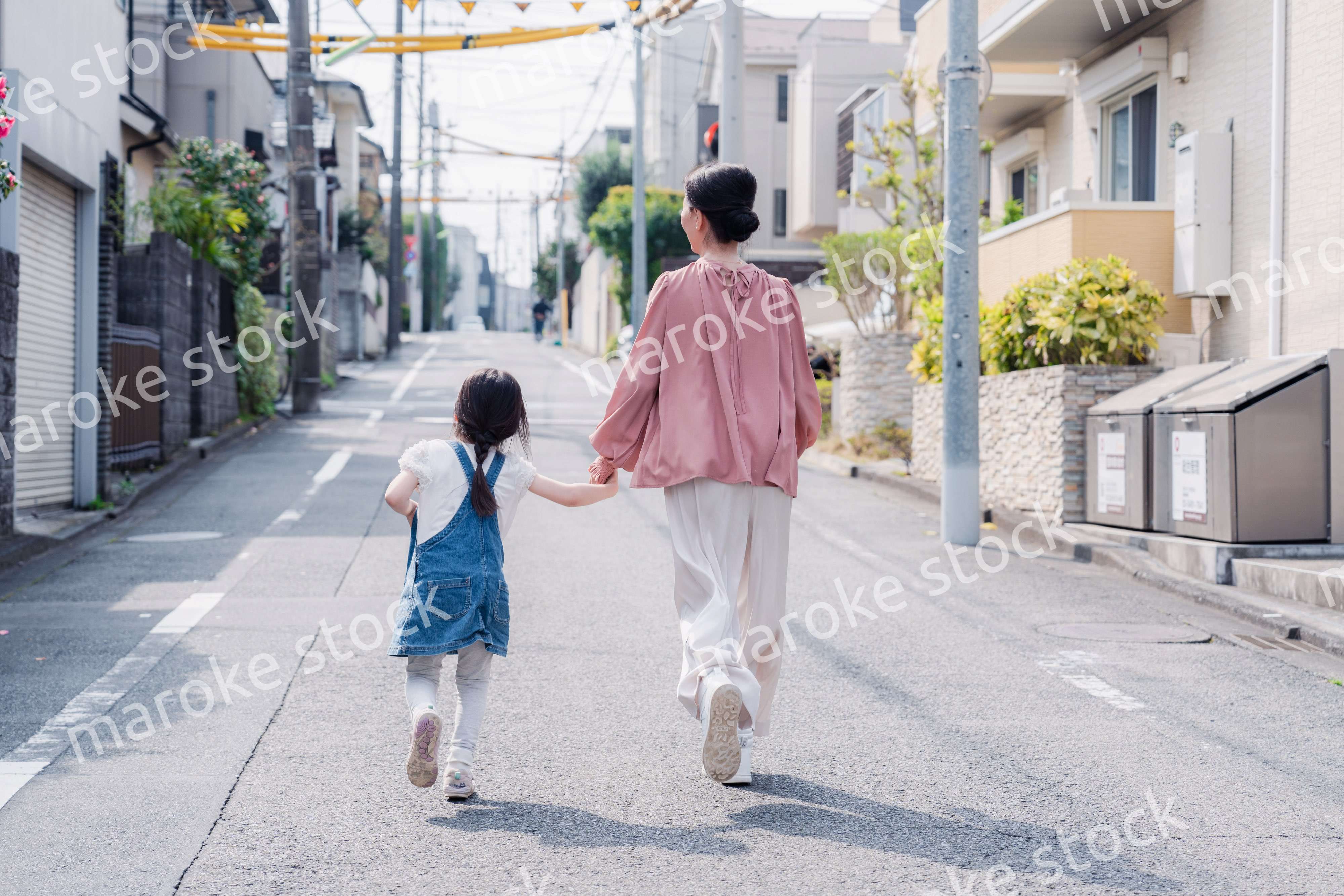 おばあちゃんと街を散歩する女の子