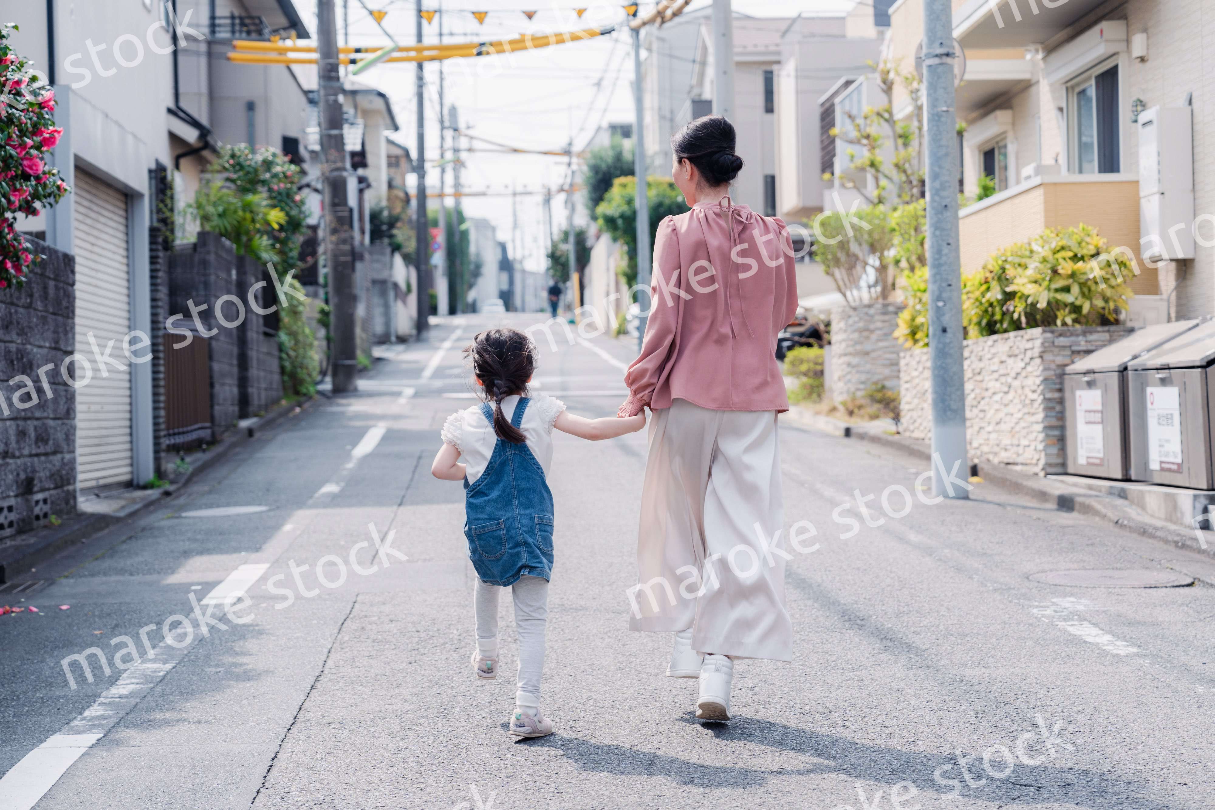 おばあちゃんと街を散歩する女の子