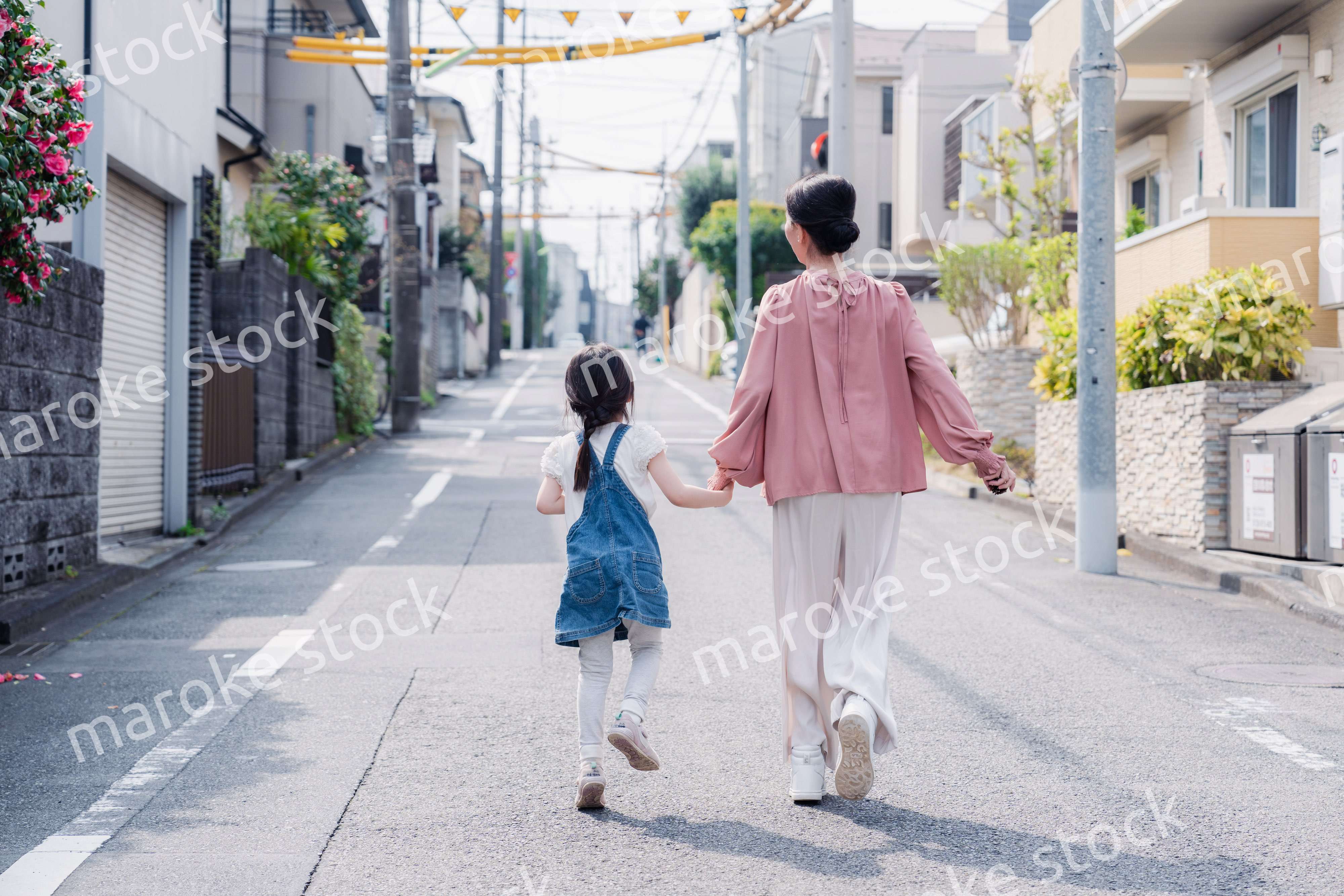 おばあちゃんと街を散歩する女の子