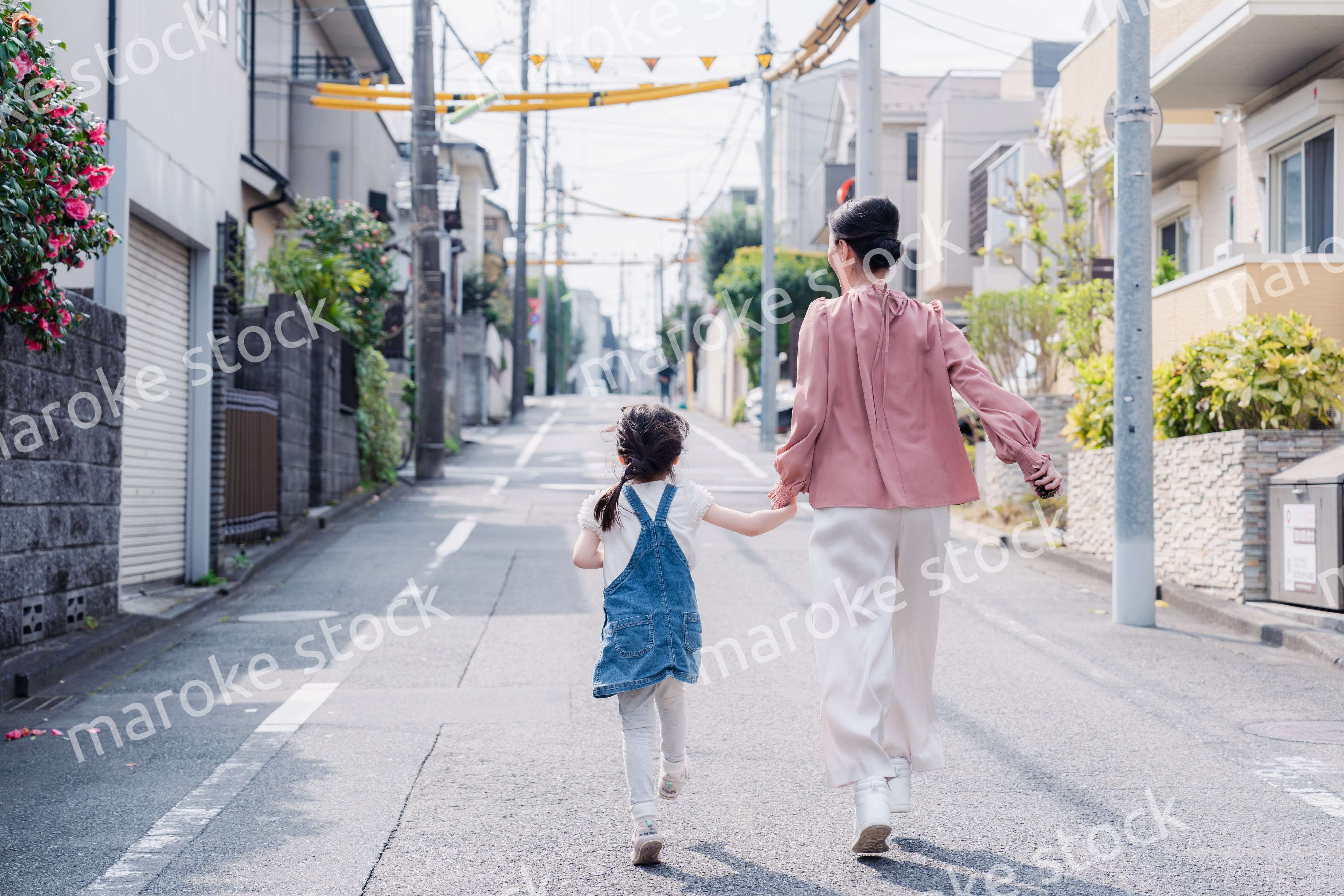 おばあちゃんと街を散歩する女の子