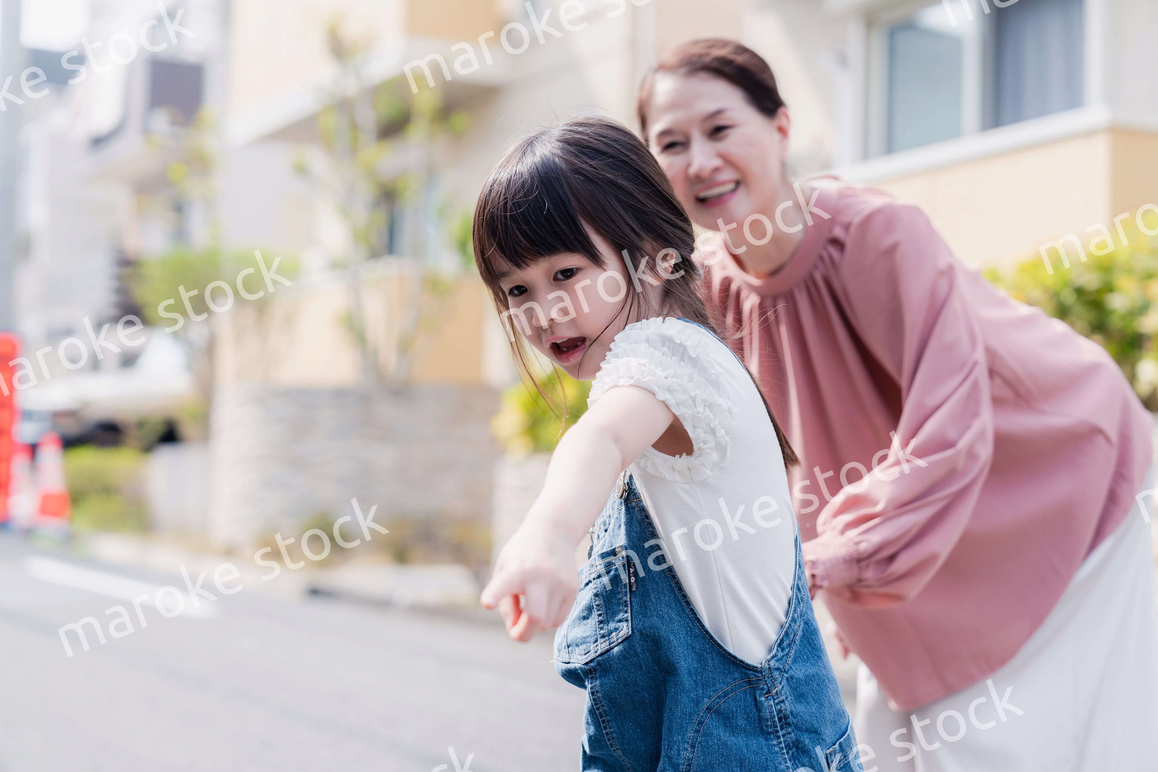 おばあちゃんと街を散歩する女の子