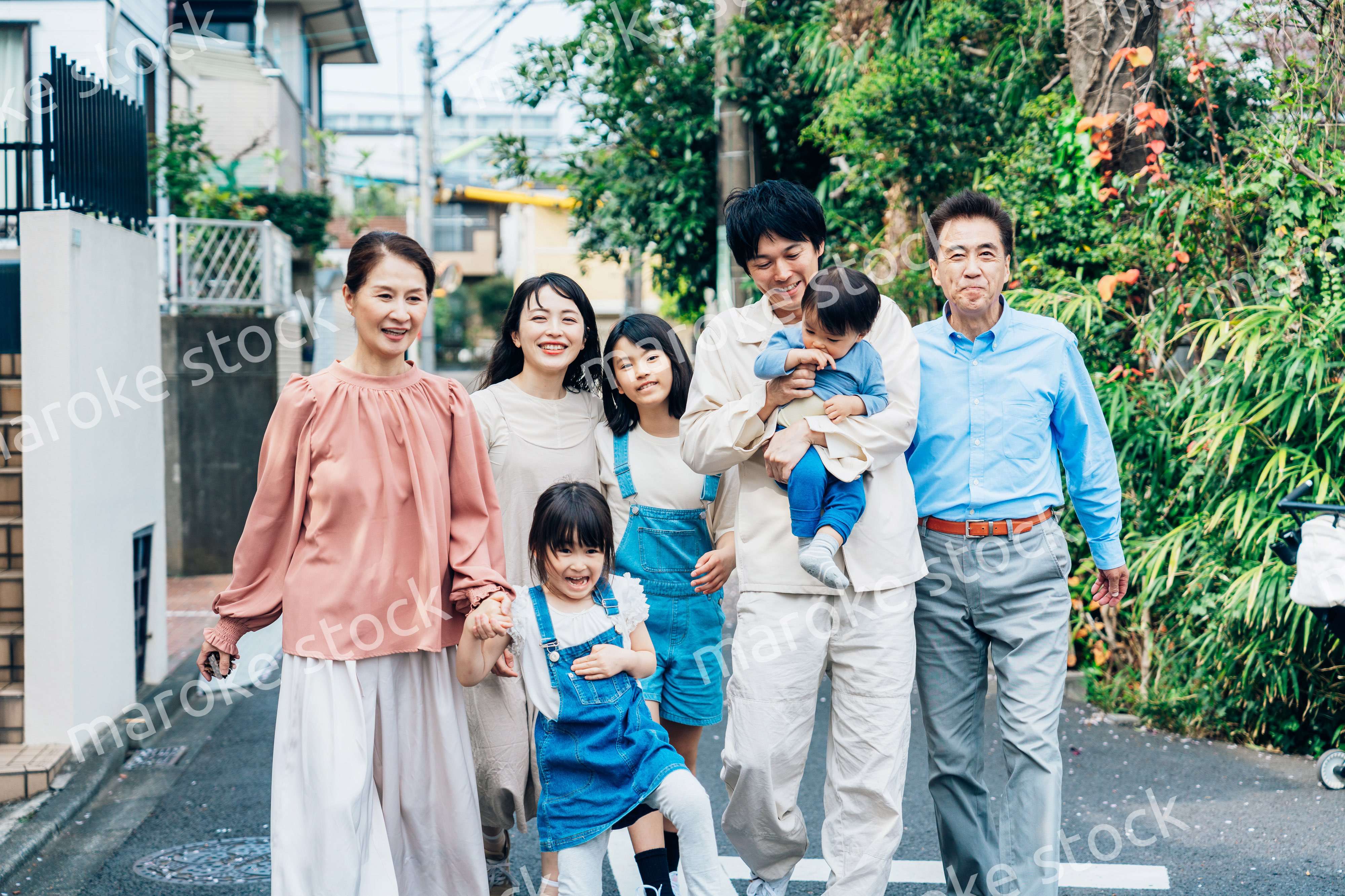 笑顔で外を散歩する3世代のファミリー