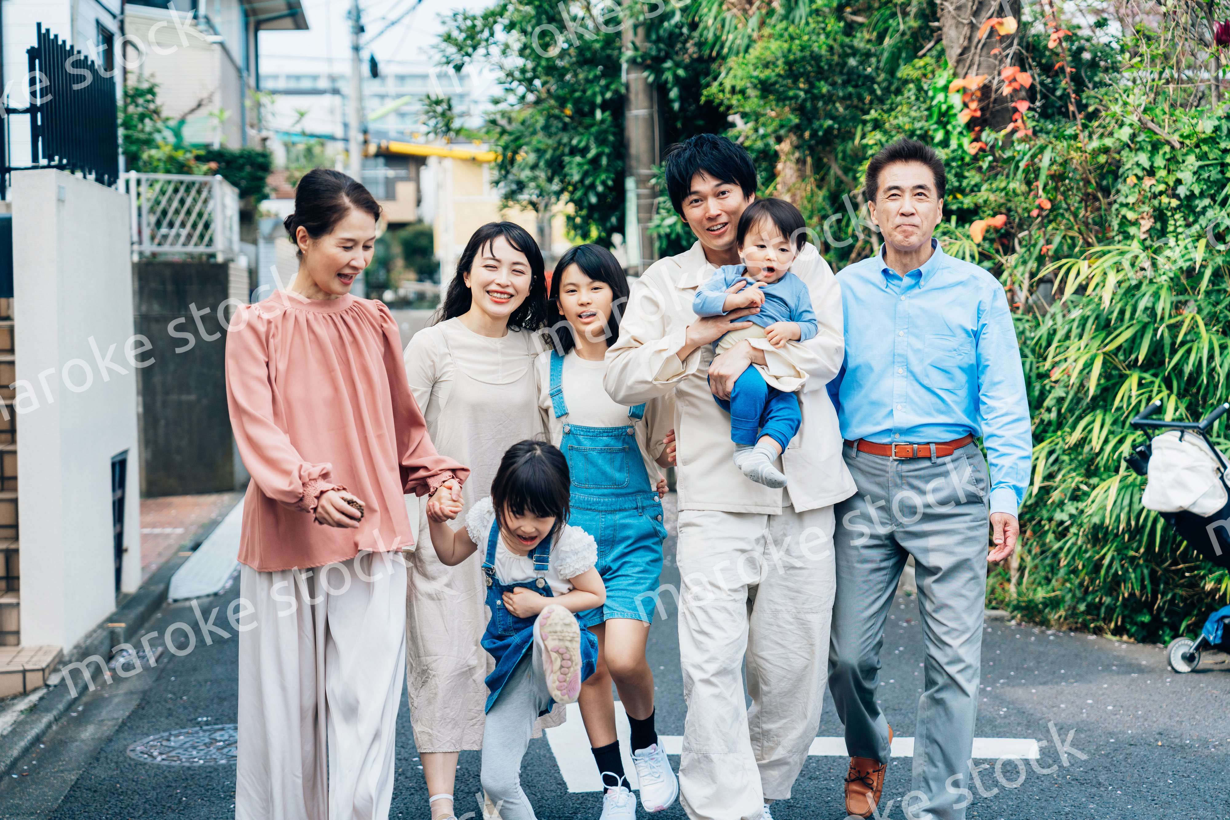 笑顔で外を散歩する3世代のファミリー