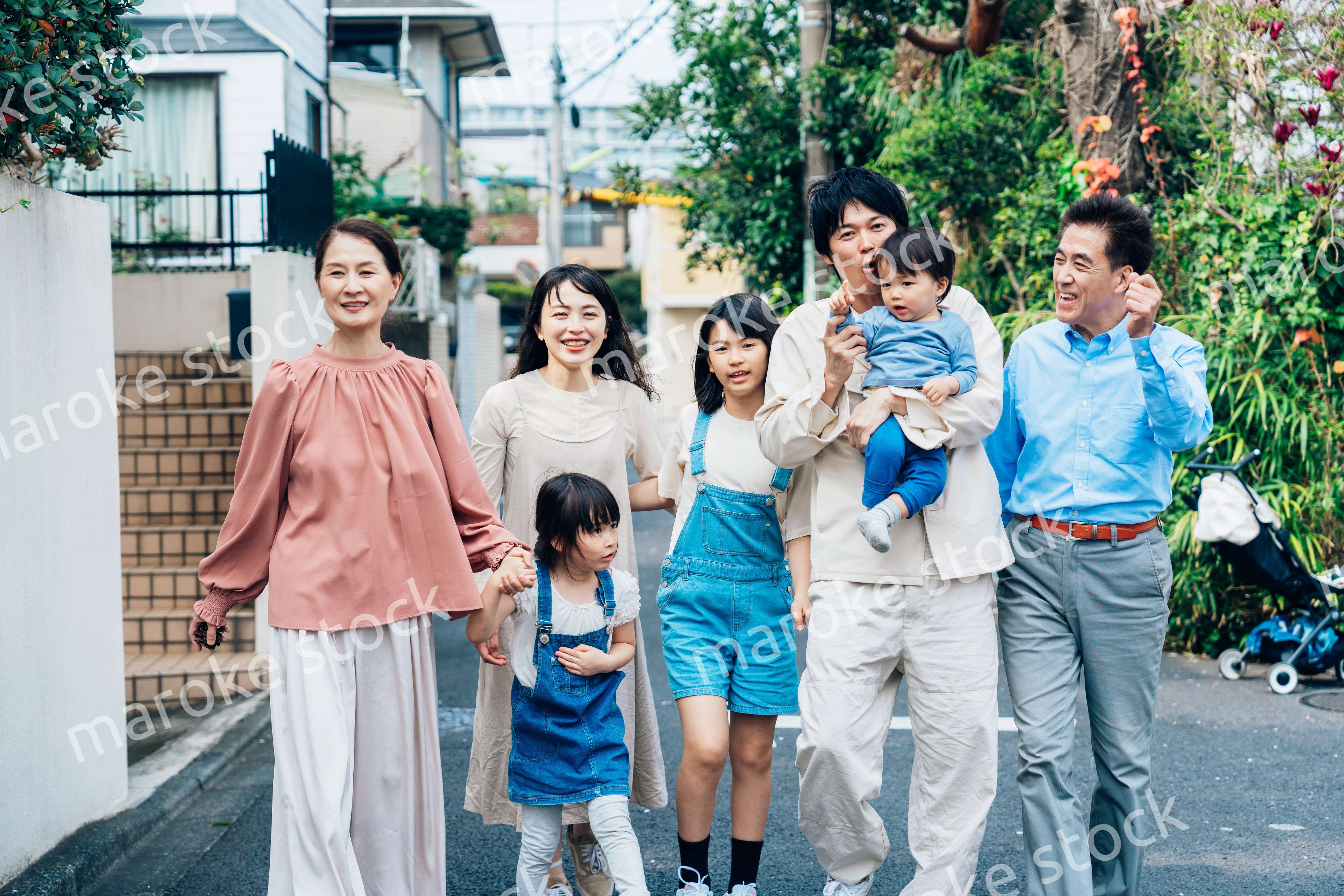 笑顔で外を散歩する3世代のファミリー