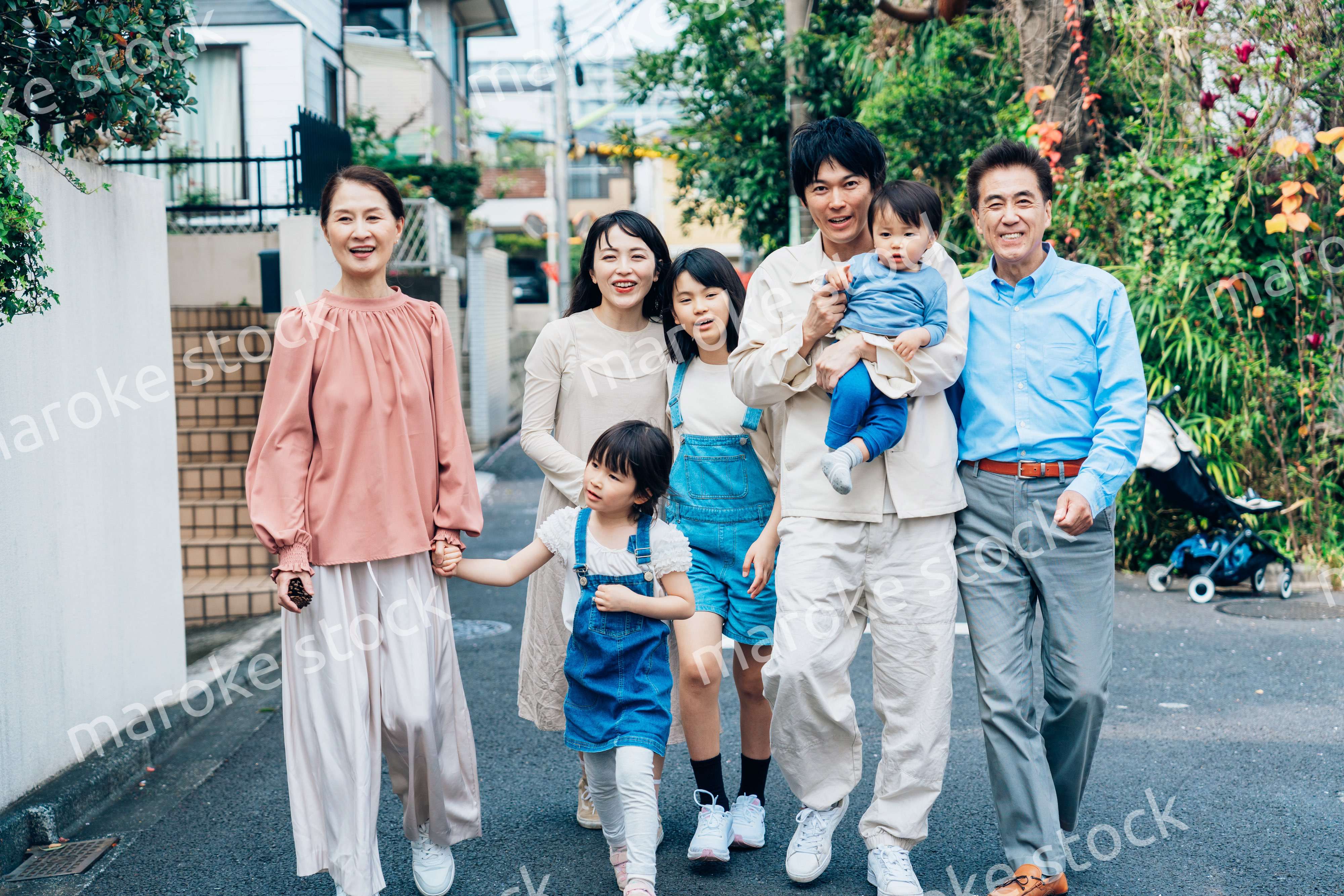 笑顔で外を散歩する3世代のファミリー