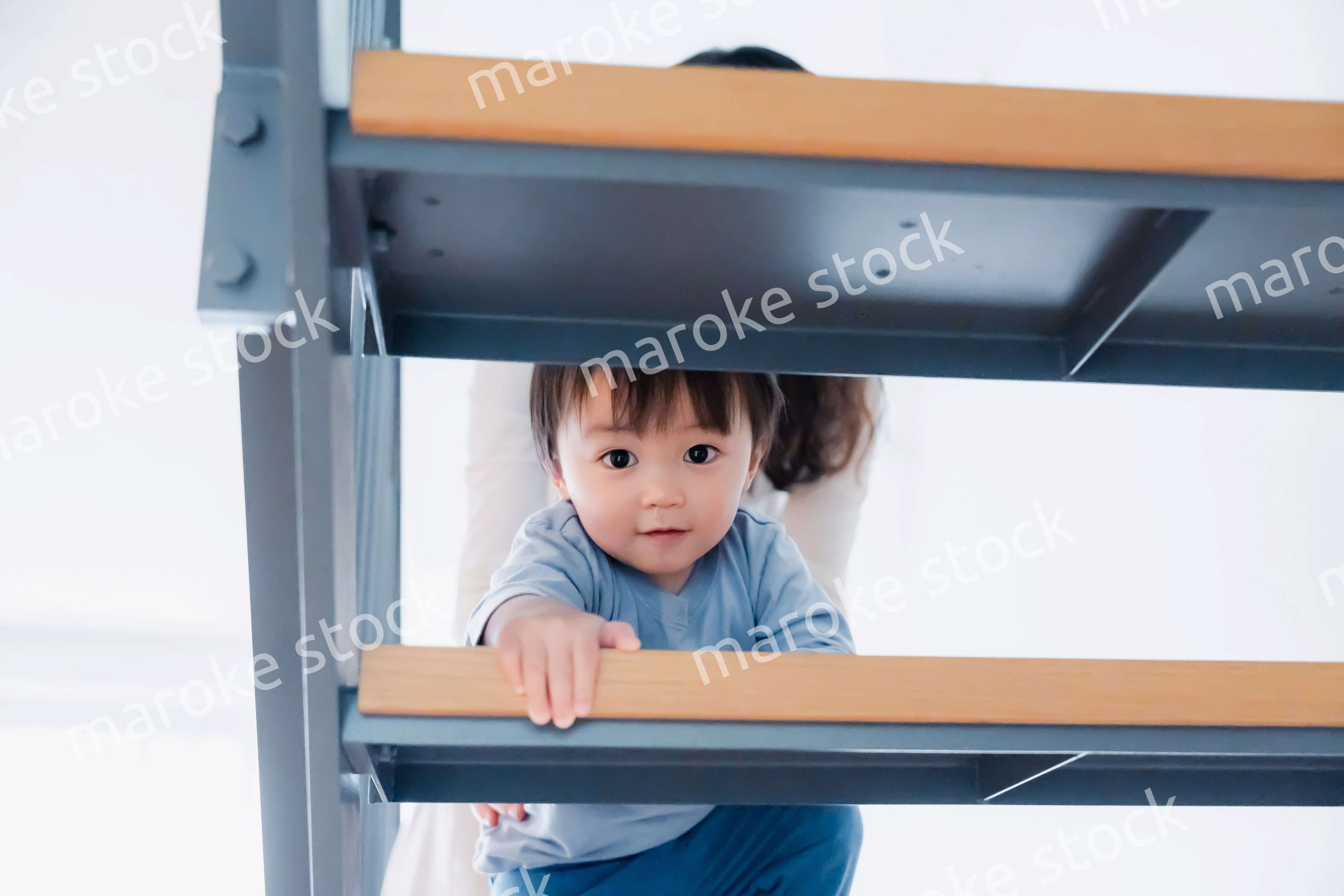 家の階段をハイハイで登る1歳の男の子