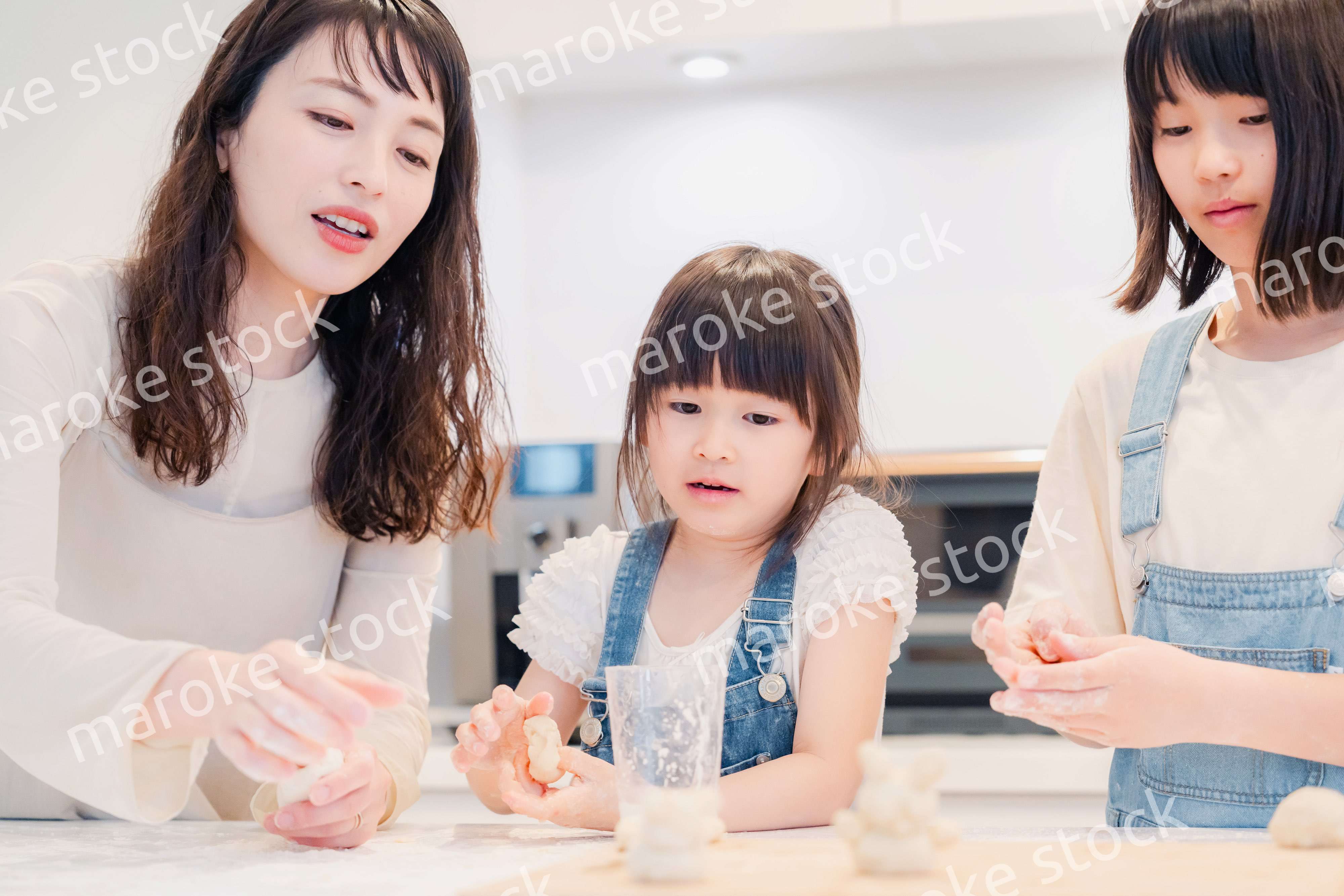 お母さんと一緒に料理をする子どもたち
