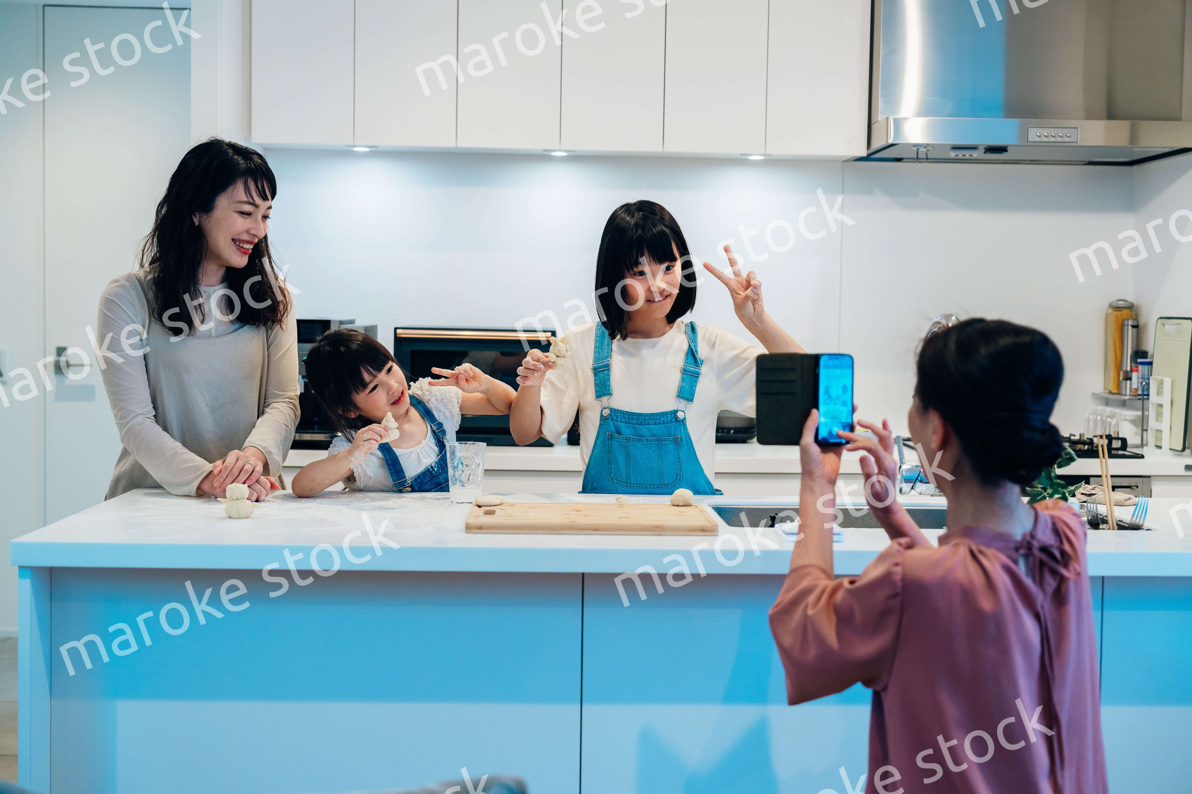 スマホで孫たちの写真を撮るおばあちゃん