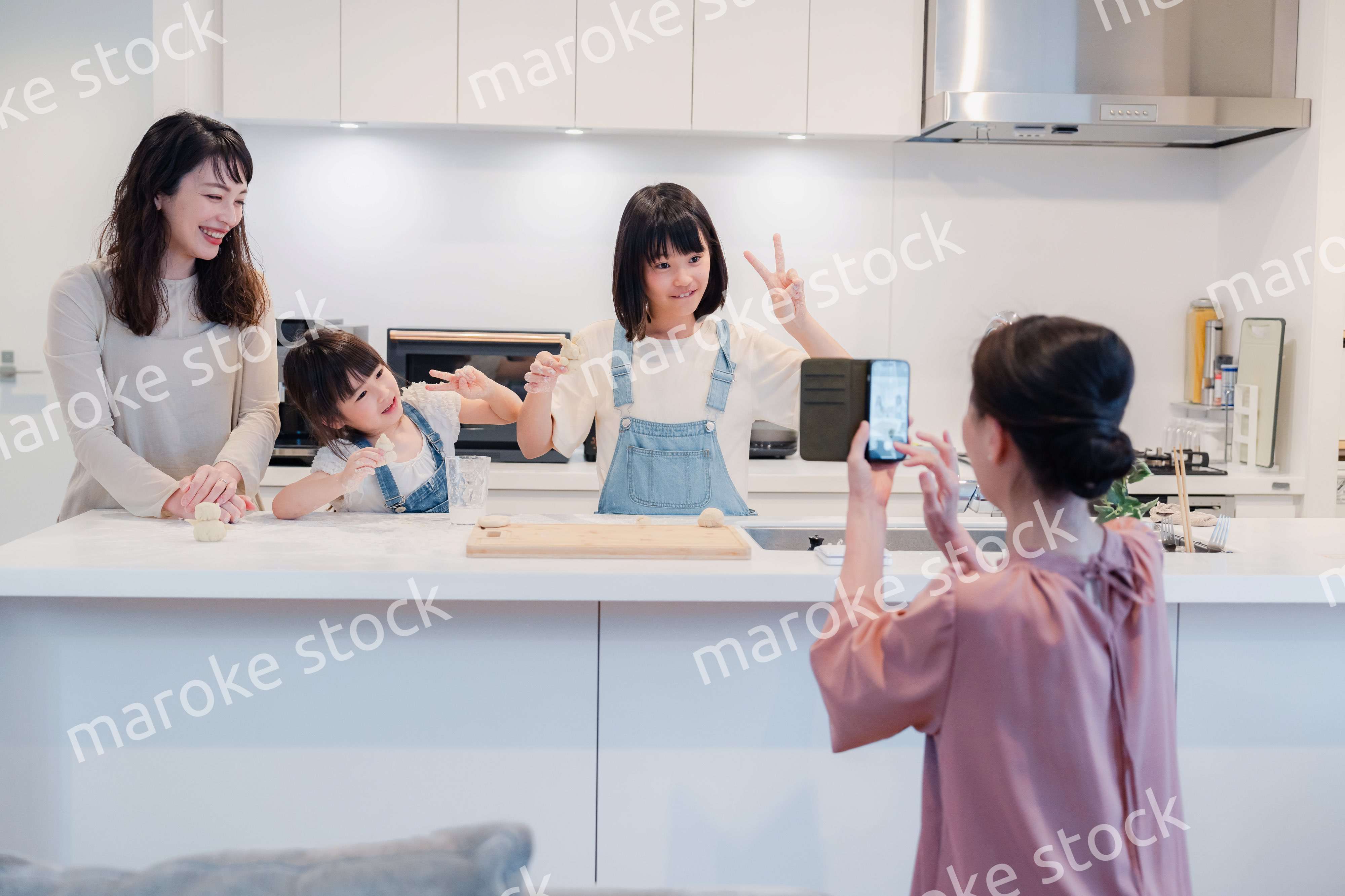 スマホで孫たちの写真を撮るおばあちゃん