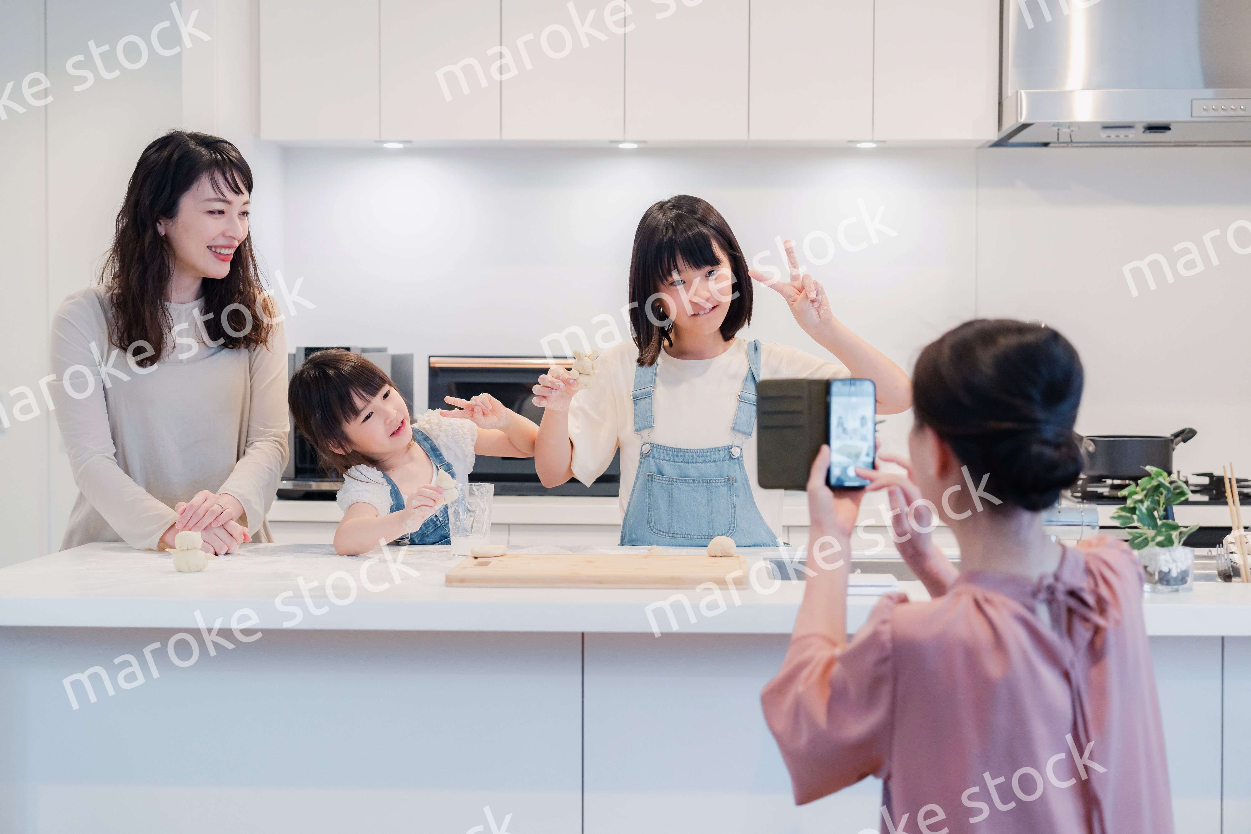 スマホで孫たちの写真を撮るおばあちゃん