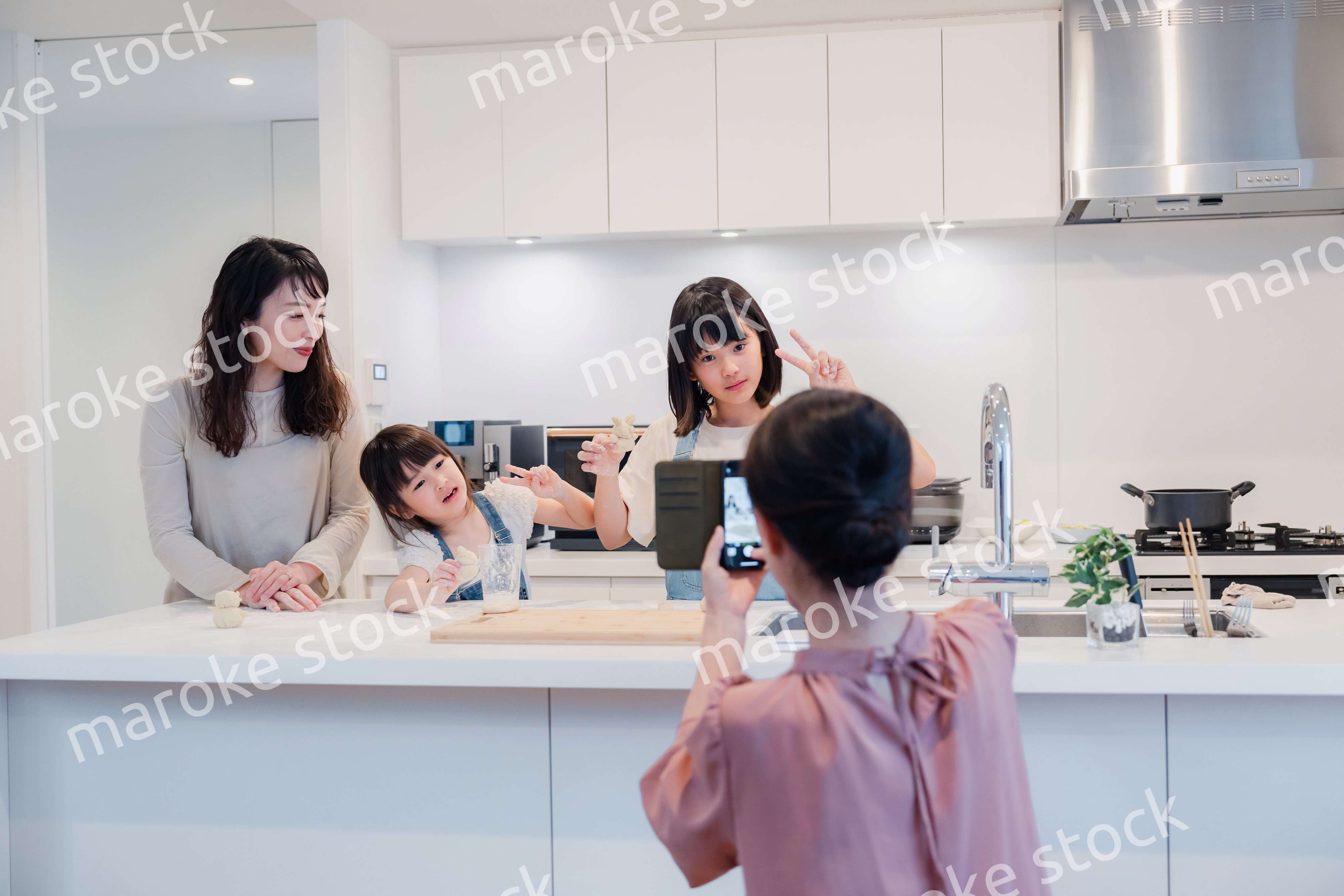 スマホで孫たちの写真を撮るおばあちゃん