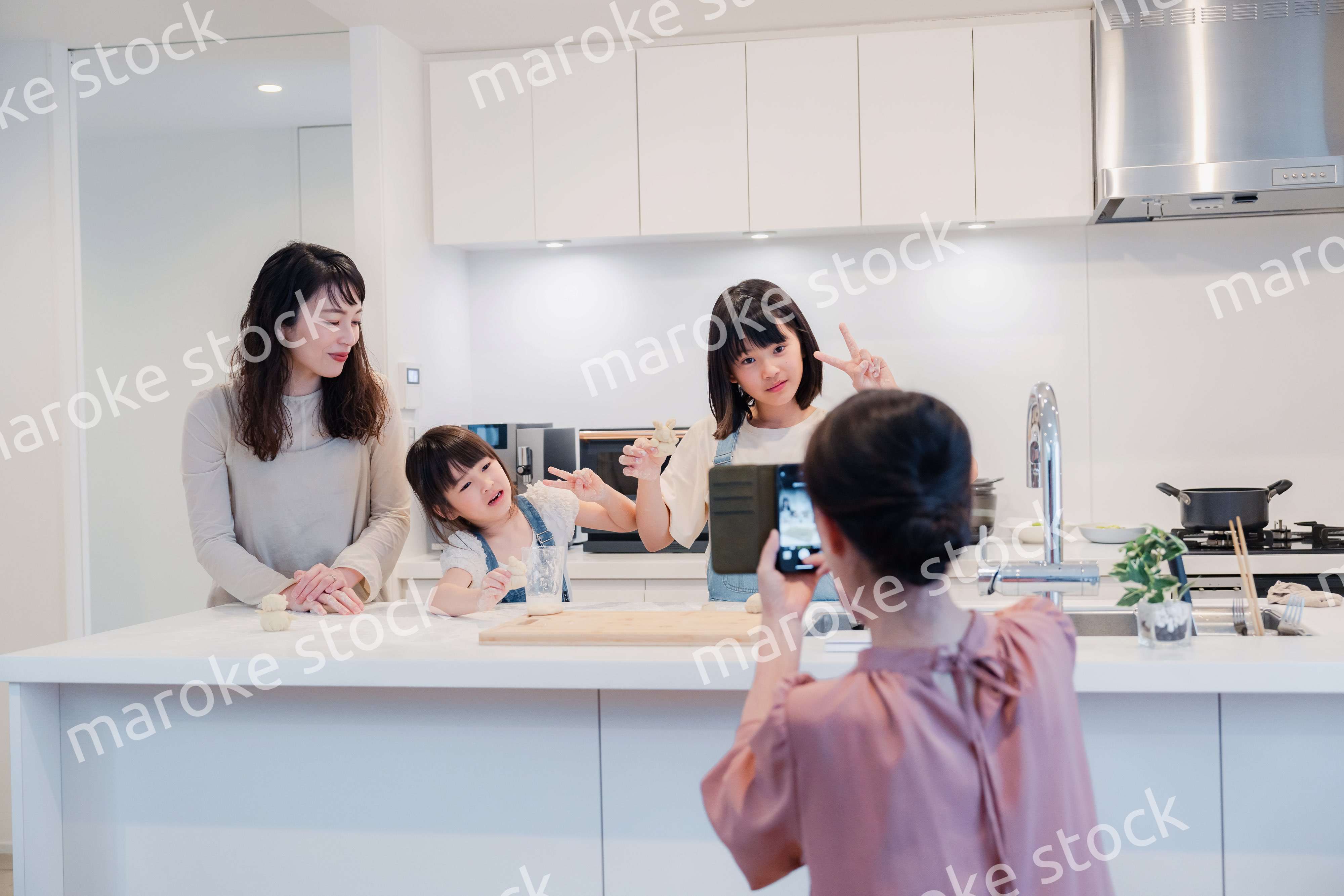 スマホで孫たちの写真を撮るおばあちゃん