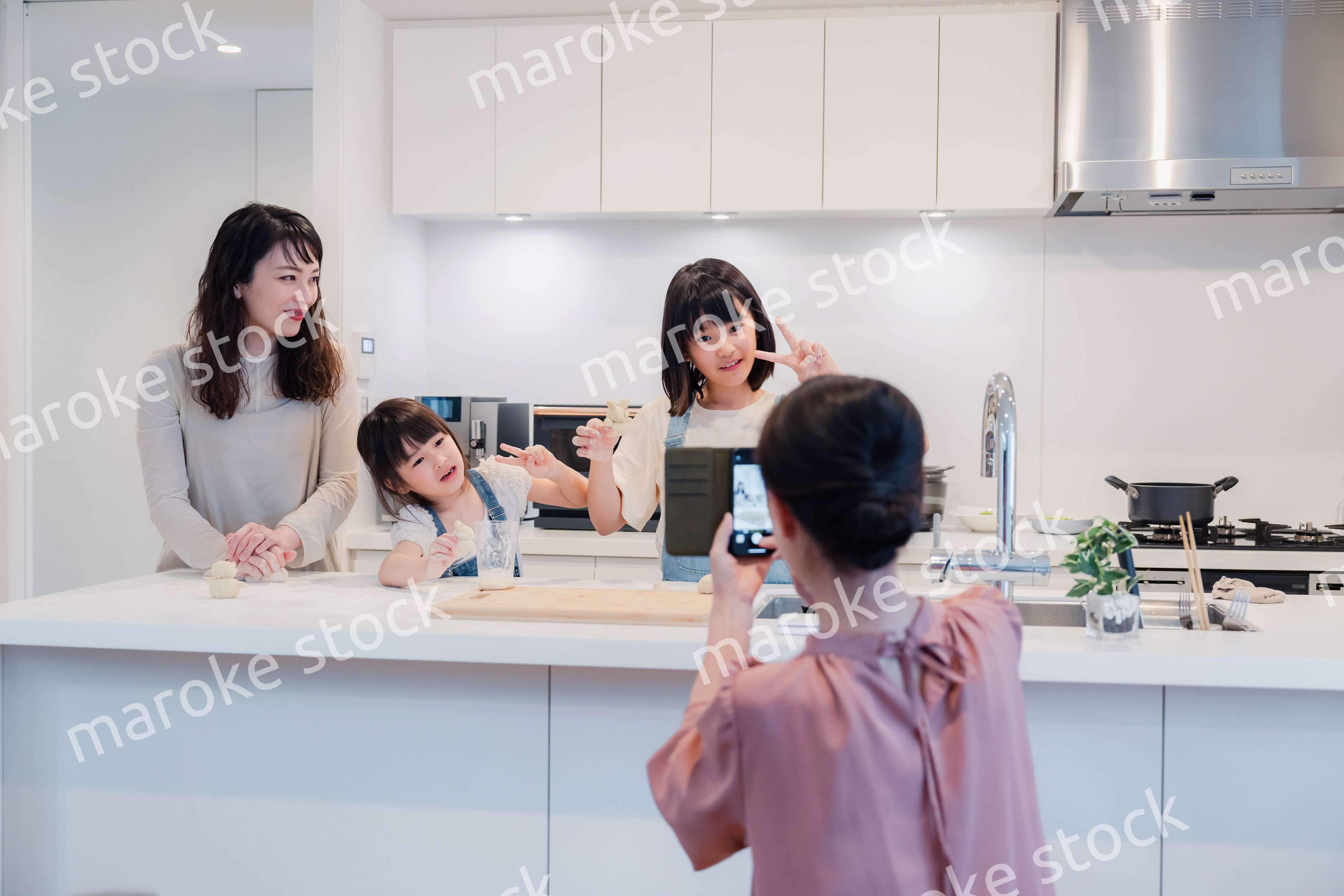 スマホで孫たちの写真を撮るおばあちゃん