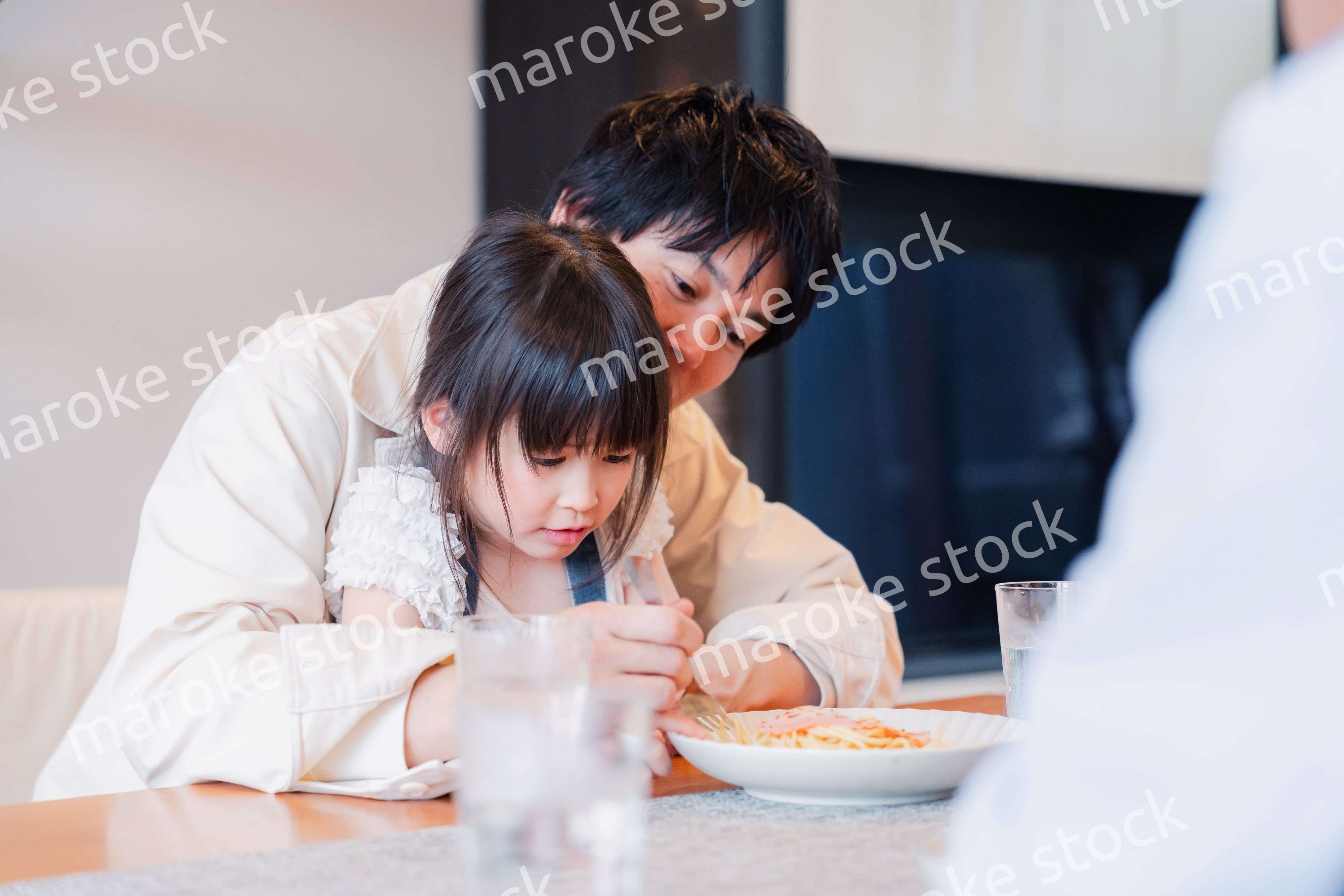 パパと一緒にご飯を食べる小さな女の子